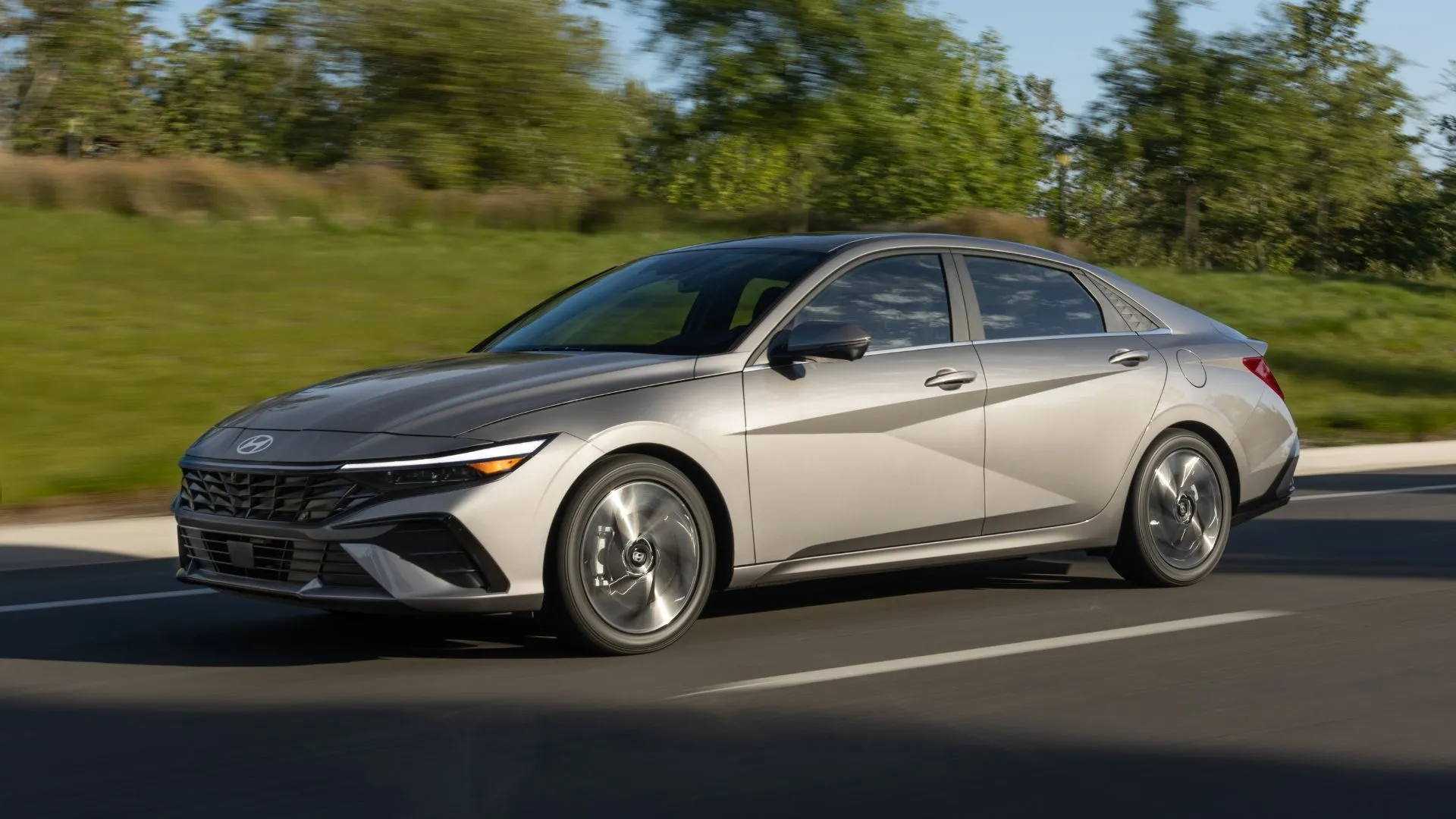 Hyundai Elantra 2025 màu xám bạc đang di chuyển trên đường cao tốc.