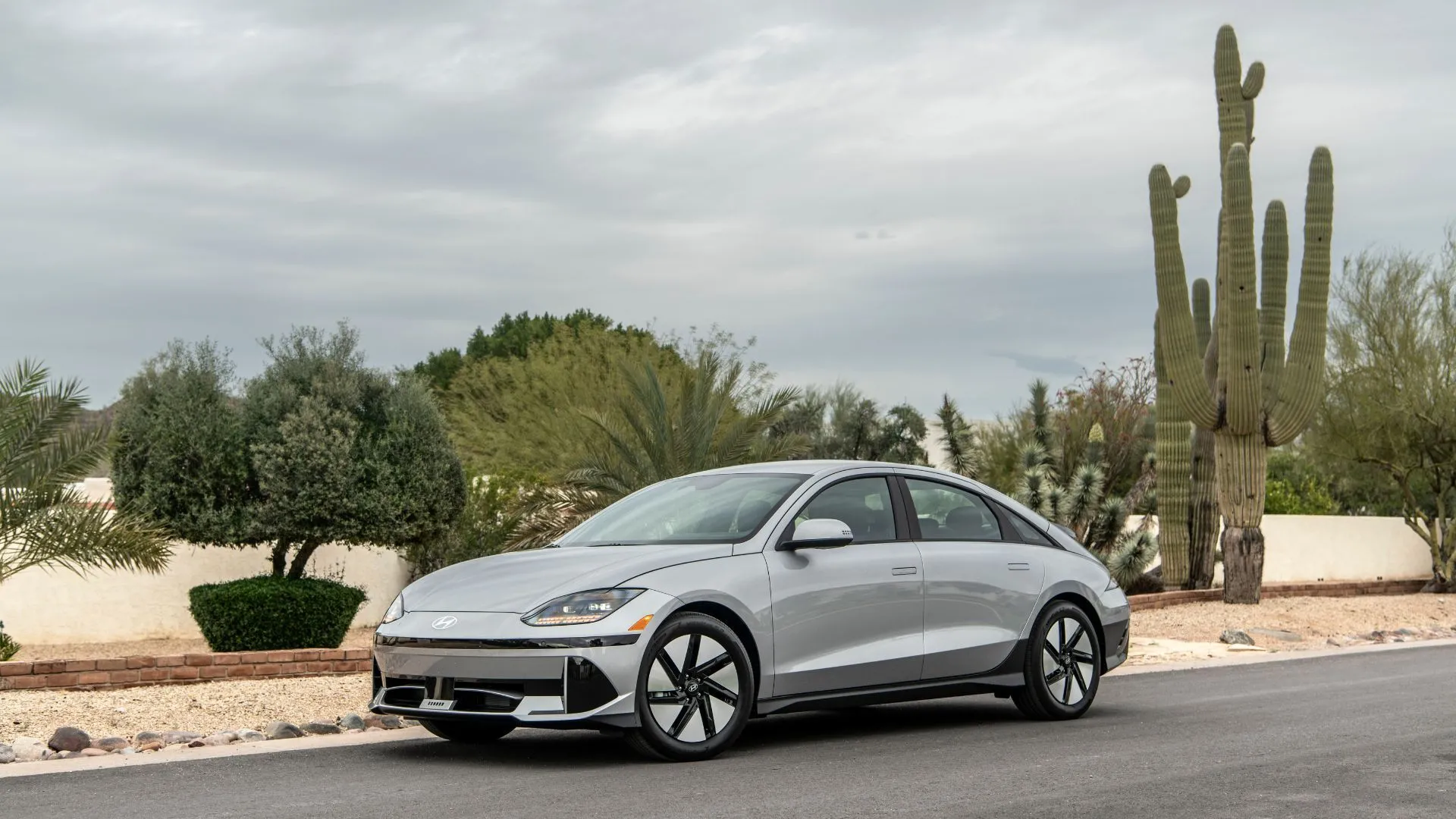 Hyundai Ioniq 6 SE RWD 2025 màu bạc với thiết kế khí động học độc đáo, đỗ cạnh cây xương rồng, nhấn mạnh sự khác biệt và hiệu quả.