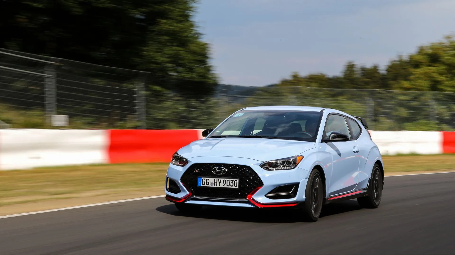 Hyundai Veloster N Coupe 2022 màu xanh dương nổi bật đang bứt tốc trên đường đua, biểu tượng của một hot hatch hiệu suất cao.