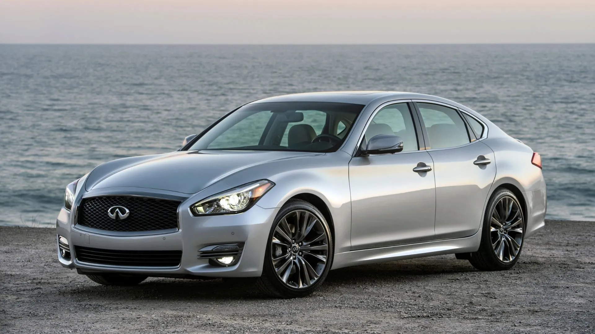 Infiniti Q70 2017 màu bạc đậu trên bãi biển, thể hiện sự kết hợp hài hòa giữa hiệu suất và vẻ đẹp thanh lịch.