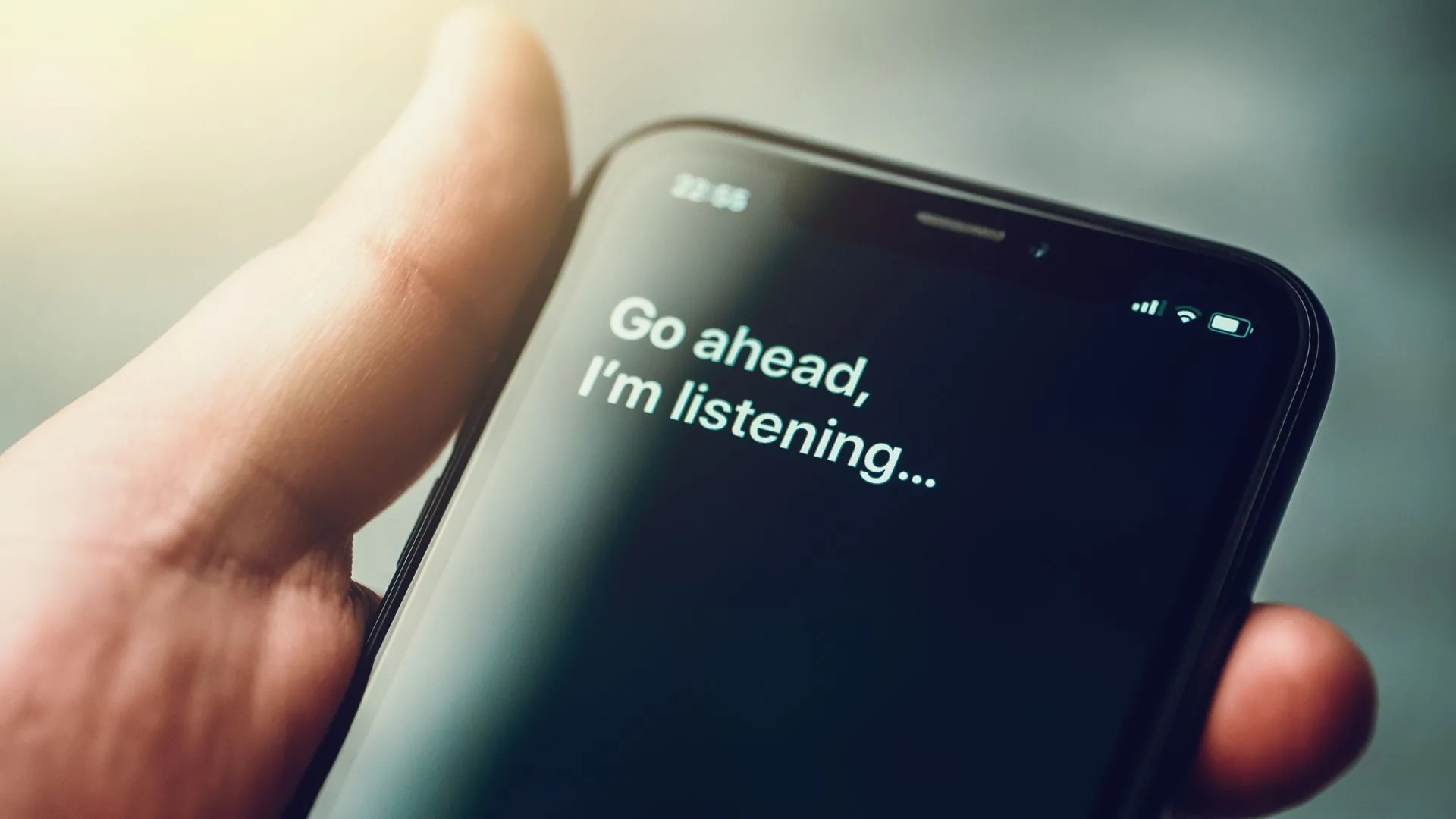 iPhone XR trong tay nam giới với trợ lý ảo Siri được kích hoạt bằng giọng nói, minh họa tính năng điều khiển bằng giọng nói trên ứng dụng định vị.