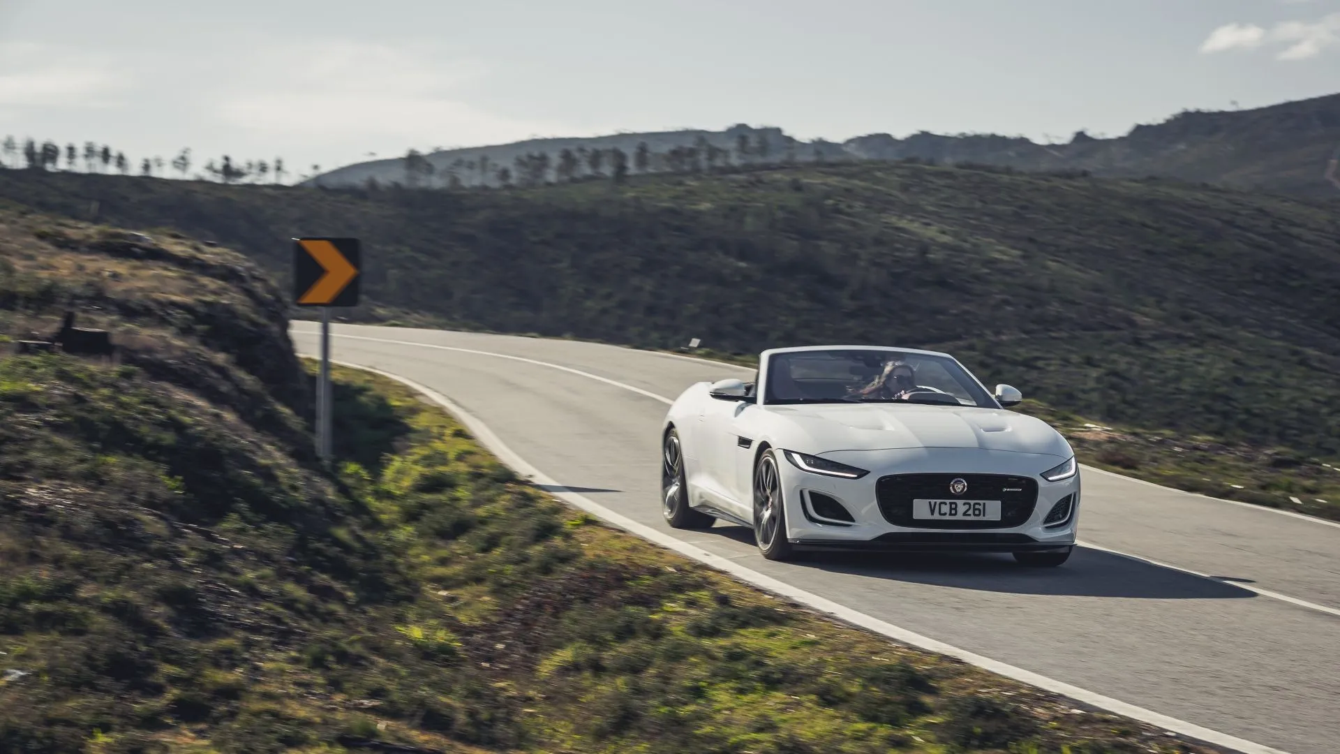 Jaguar F-Type 2022 màu trắng đang chạy trên đường đèo, biểu tượng xe thể thao Anh quốc với tỷ lệ khấu hao cao