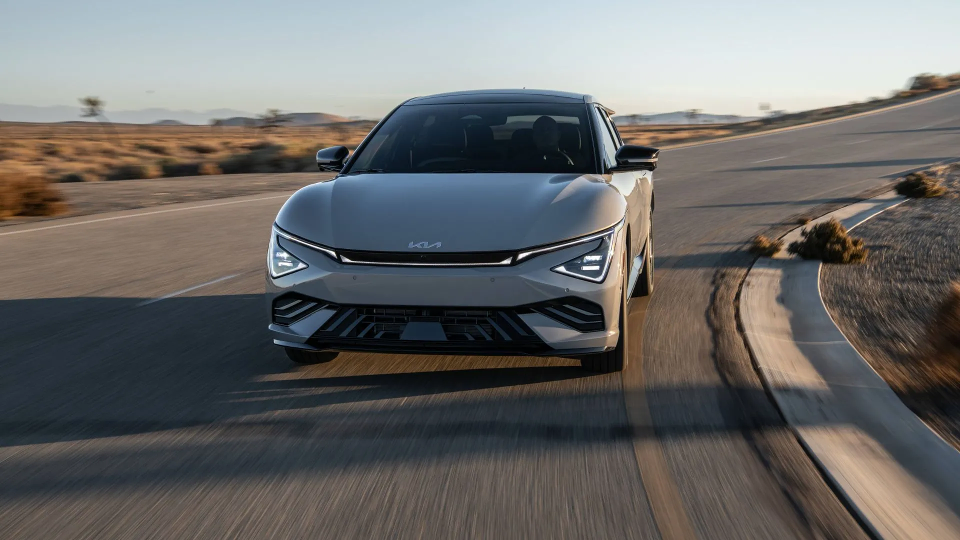 Kia EV6 Light Long Range RWD 2025 màu xám bạc lướt nhẹ trên con đường nông thôn, khoe vẻ ngoài thể thao và hiện đại.