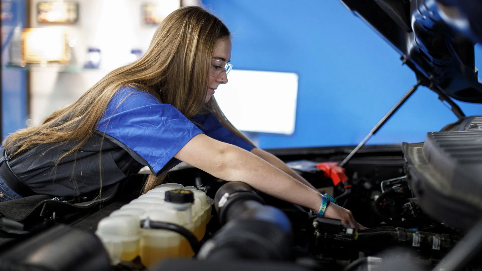 Kỹ thuật viên Ford đang kiểm tra khoang động cơ ô tô, thể hiện quy trình bảo dưỡng xe