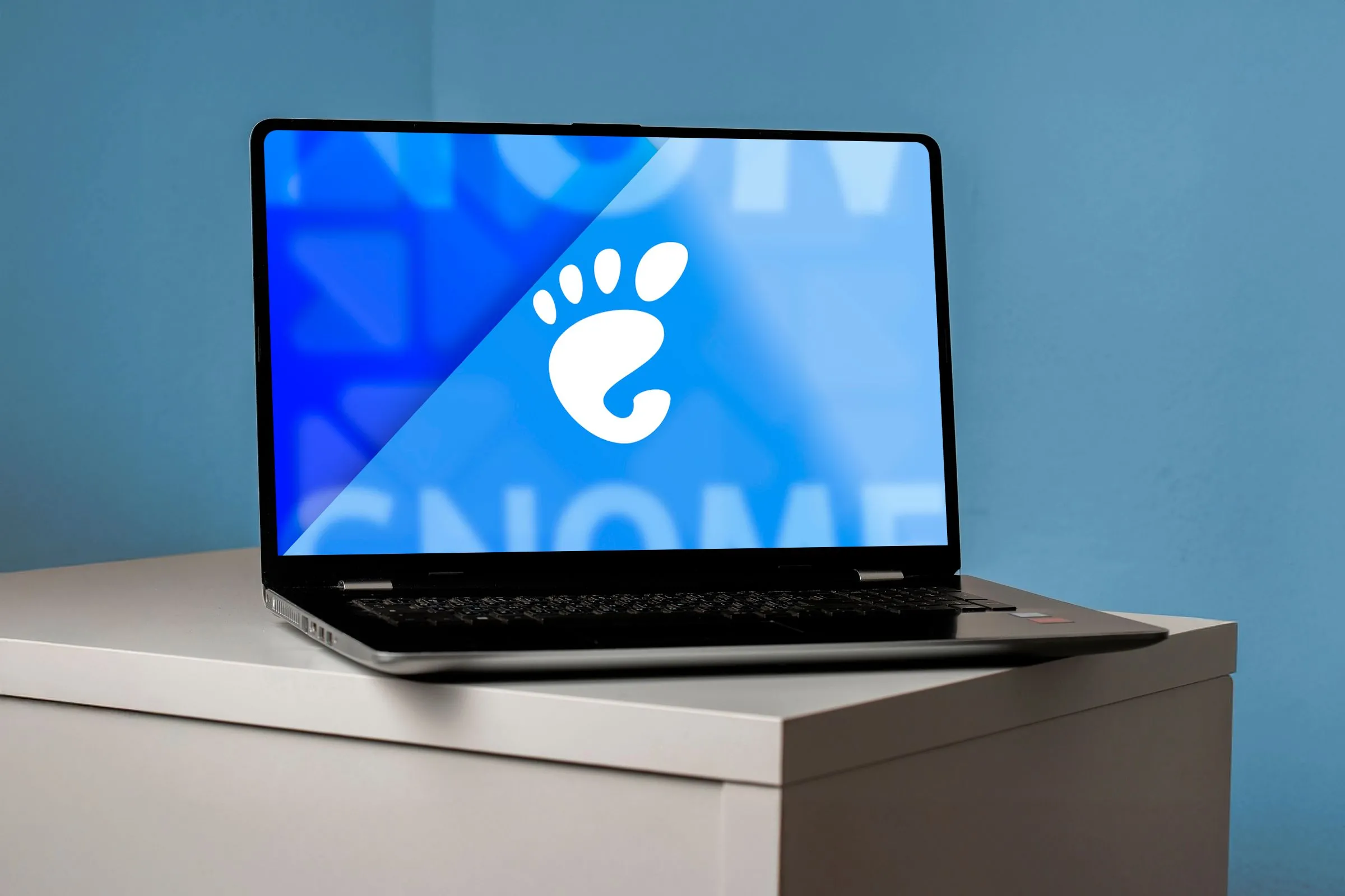 Laptop hiển thị logo GNOME trên màn hình, tượng trưng cho môi trường desktop mã nguồn mở