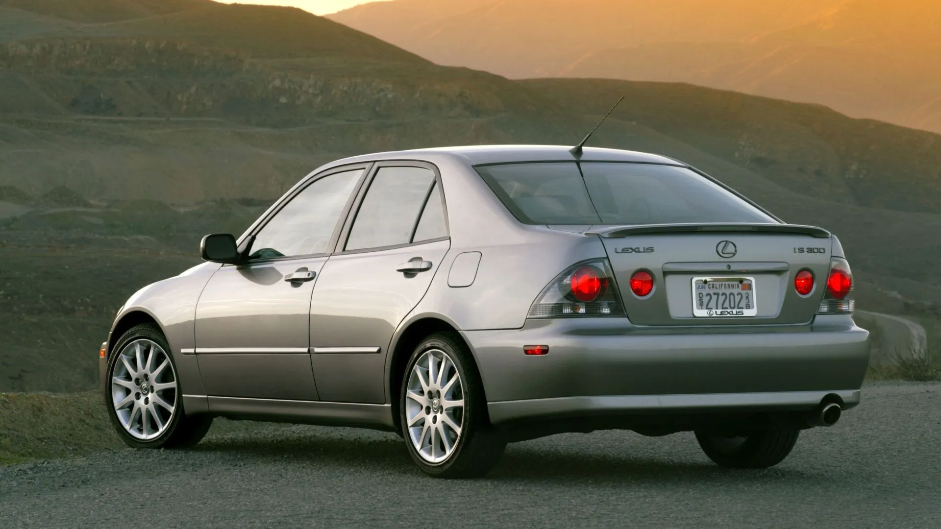 Lexus IS300 đời 2003 màu bạc nhìn từ góc phía trước bên hông, nổi bật với đèn hậu tròn đặc trưng.