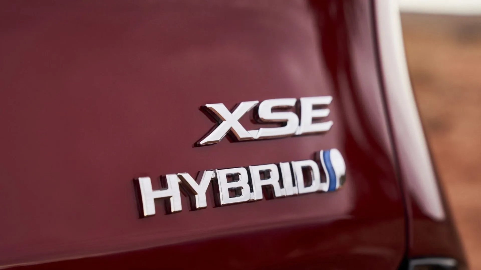 Logo Hybrid và tên mẫu xe Toyota Sienna 2025 trên đuôi xe màu đỏ, nhấn mạnh tính năng tiết kiệm nhiên liệu
