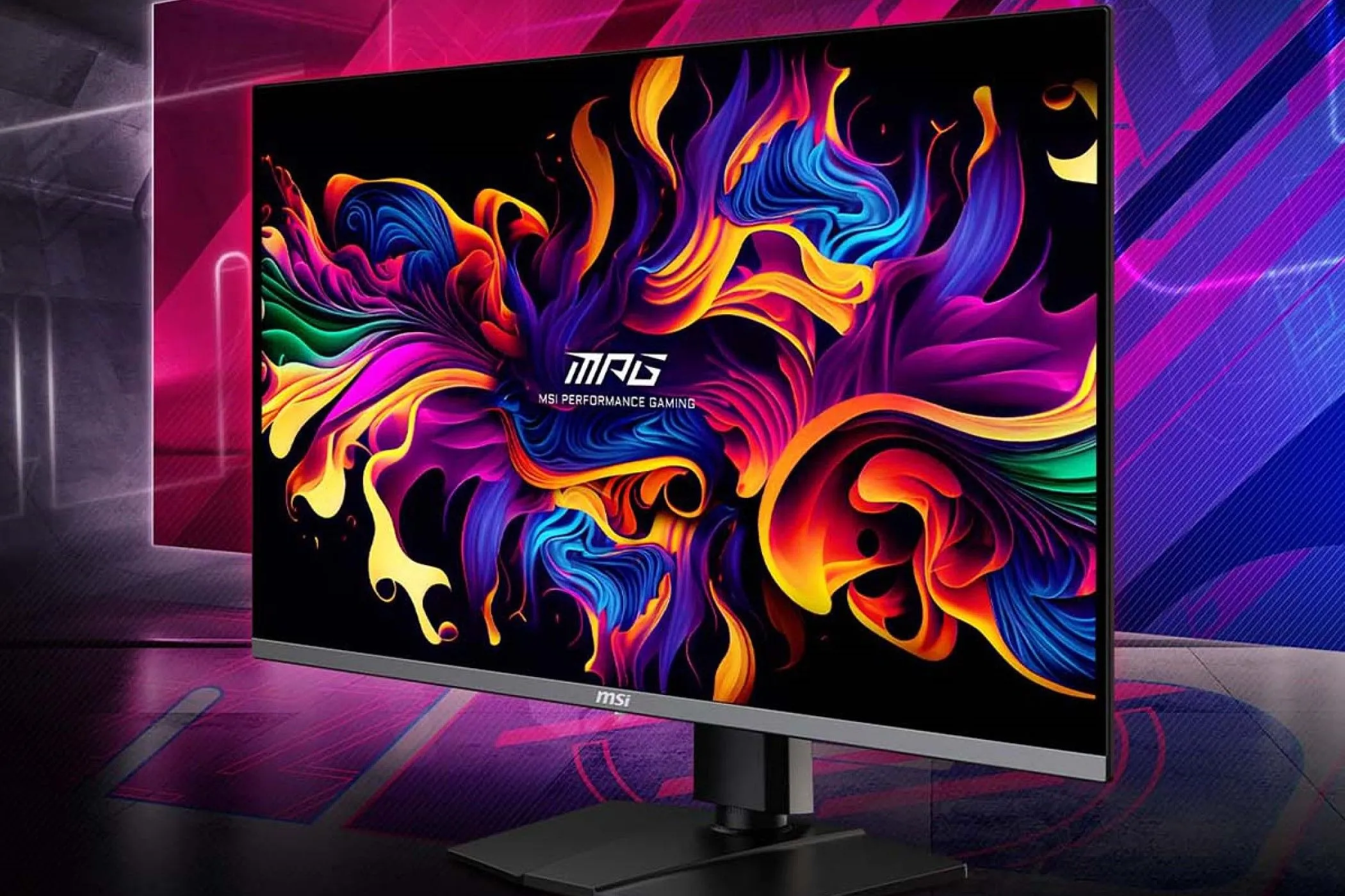 Màn hình MSI MPG321URX trên bàn làm việc, với nền đa sắc.