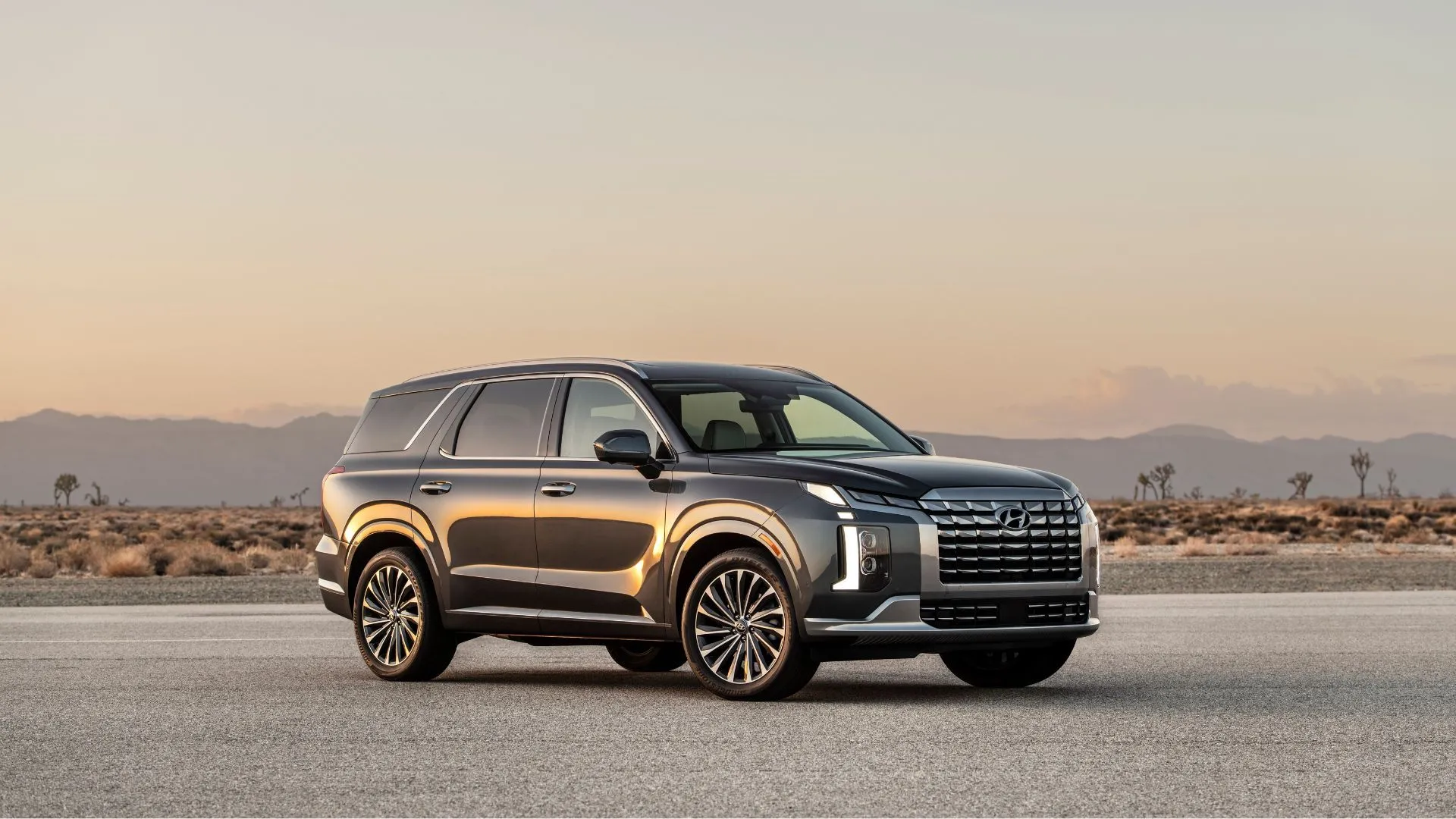 Mẫu SUV Hyundai Palisade 2025 màu xanh đậm đang di chuyển, một trong những mẫu xe bị triệu hồi vì nguy cơ cháy.