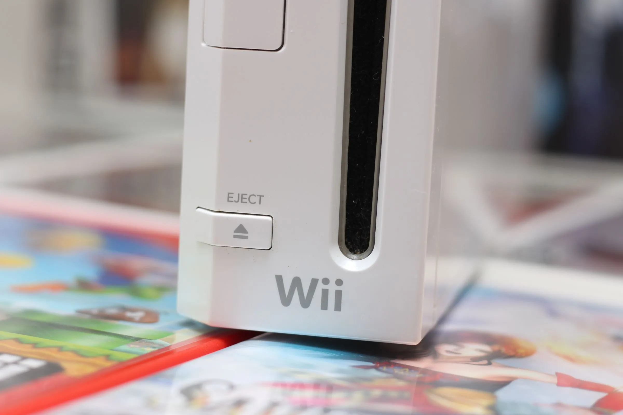 Máy chơi game Nintendo Wii màu trắng đặt trên một bề mặt, thể hiện sự đơn giản của thiết kế.