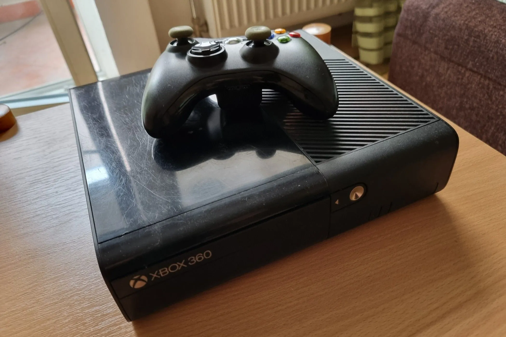 Máy Xbox 360 E đã qua sử dụng kèm tay cầm, gợi nhớ trải nghiệm chơi game console retro đầy cuốn hút.