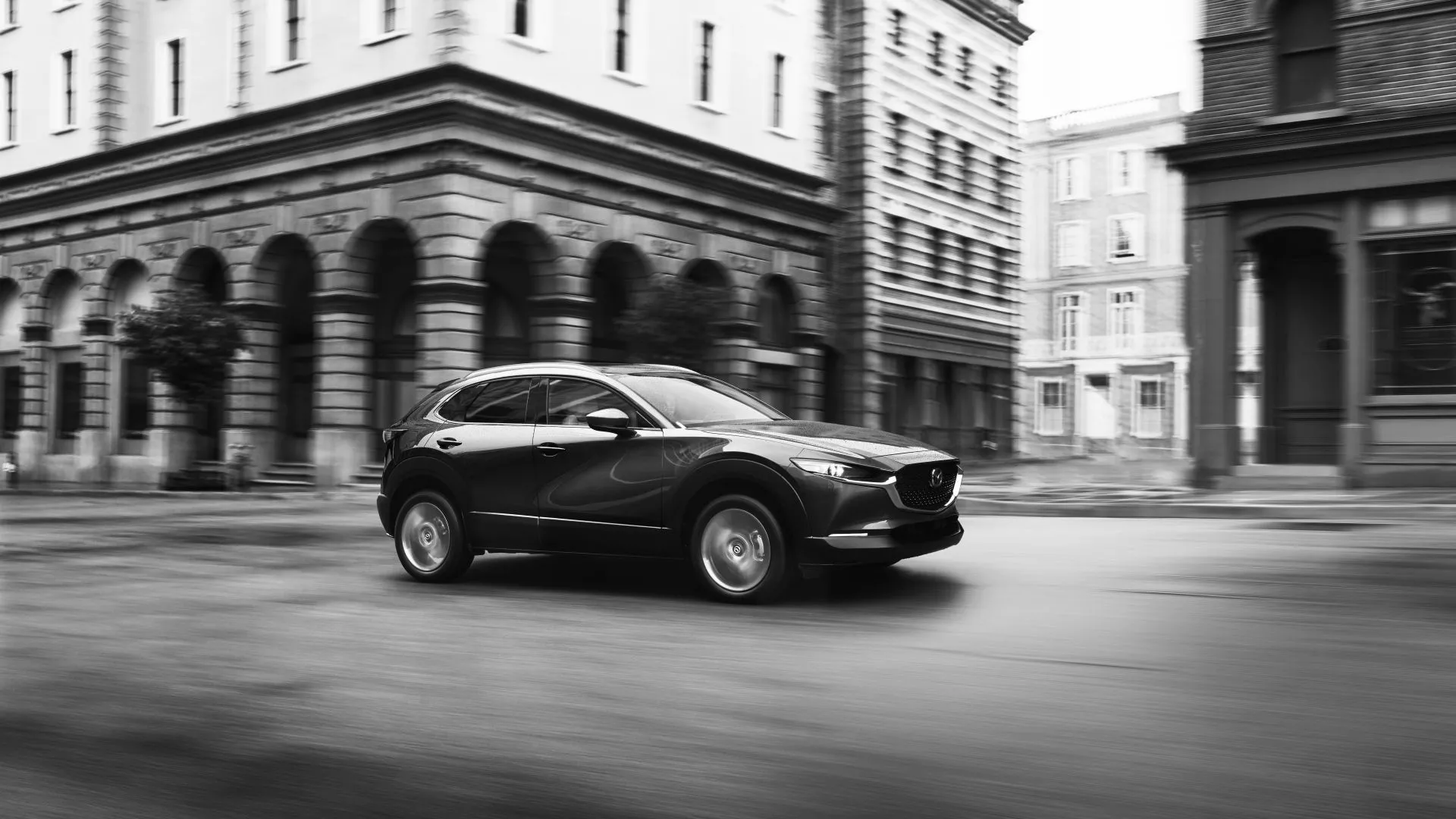 Mazda CX-30 2023 màu đỏ nhìn từ góc 3/4 phía trước đang di chuyển trên đường
