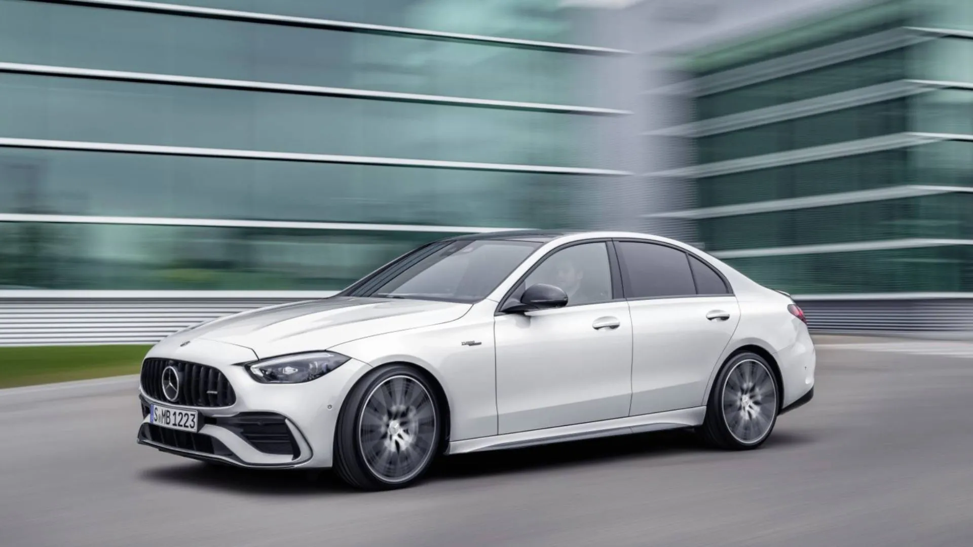 Mercedes-AMG C43 màu trắng chạy trên phố có kiến trúc hiện đại