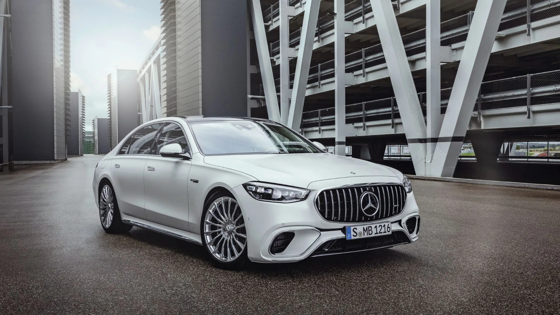 Mercedes-AMG S 63 E PERFORMANCE 2025 màu trắng đỗ trên đường nhựa, thể hiện sự kết hợp giữa sang trọng và công nghệ hybrid