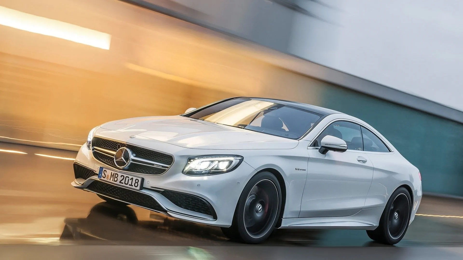 Mercedes-AMG S63 Coupe 2015 màu trắng đang di chuyển mạnh mẽ trên đường, biểu tượng của sự sang trọng và hiệu suất đỉnh cao từ Mercedes-Benz