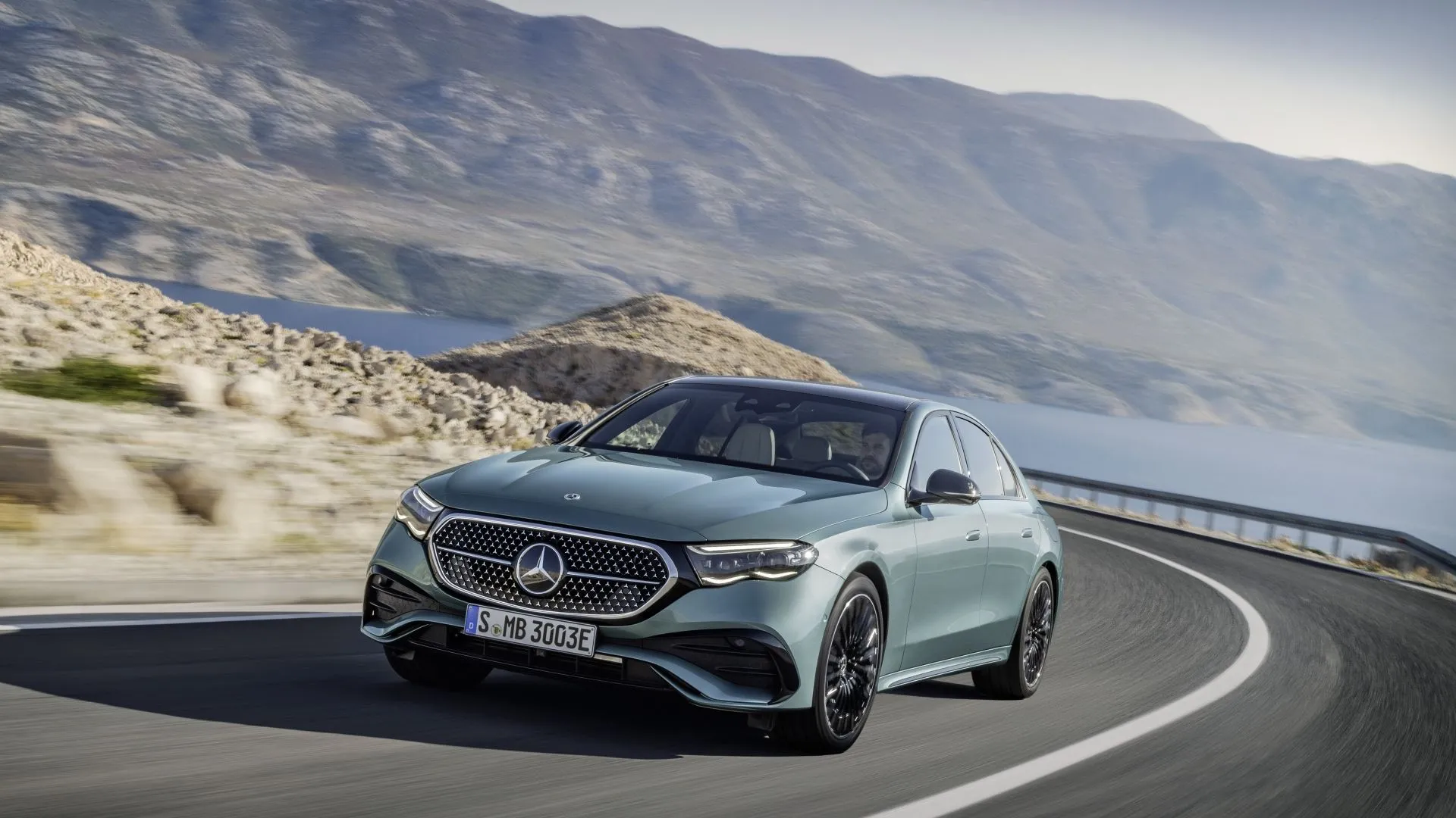 Mercedes-Benz E-Class 2025 màu bạc đang di chuyển, với góc nhìn 3/4 phía trước, toát lên vẻ đẳng cấp và công nghệ tiên tiến của dòng sedan hạng sang.