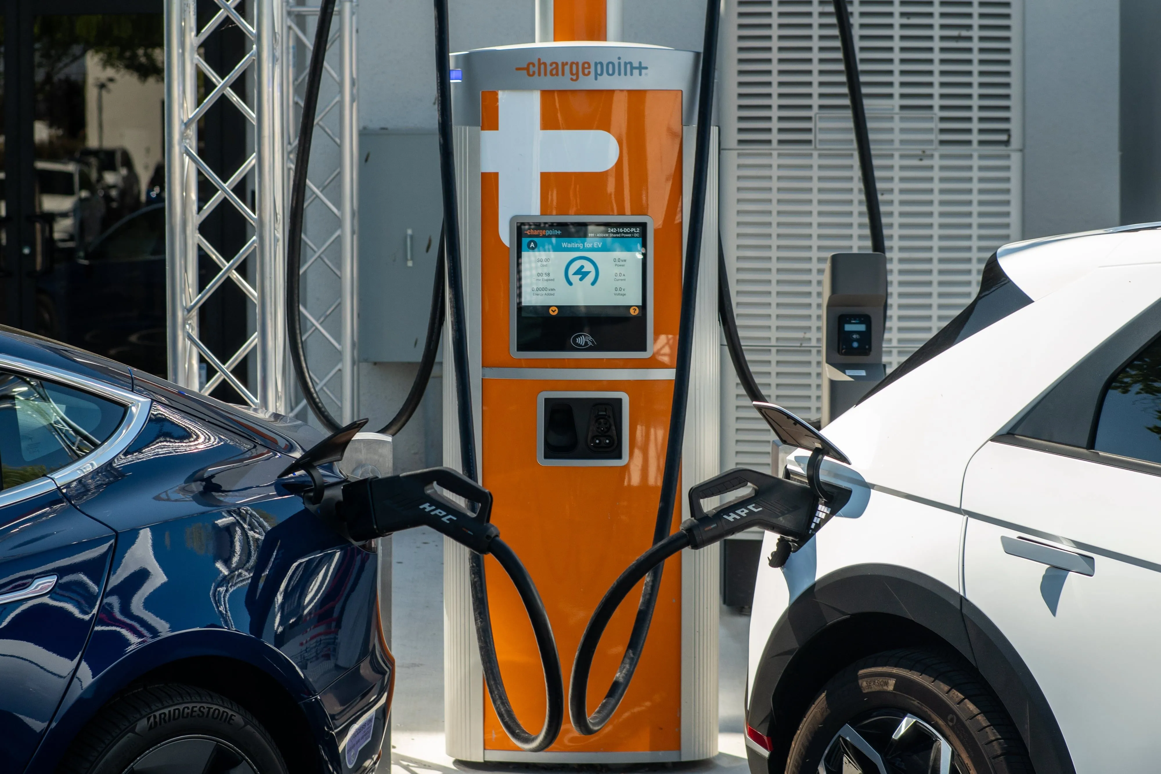 Minh họa trạm sạc xe điện ChargePoint đang sạc hai chiếc xe điện, nhấn mạnh tầm quan trọng của hạ tầng sạc nhanh