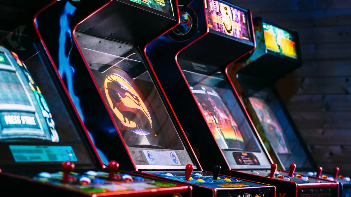 Một bộ sưu tập các máy game thùng cổ điển trong một căn phòng tối.