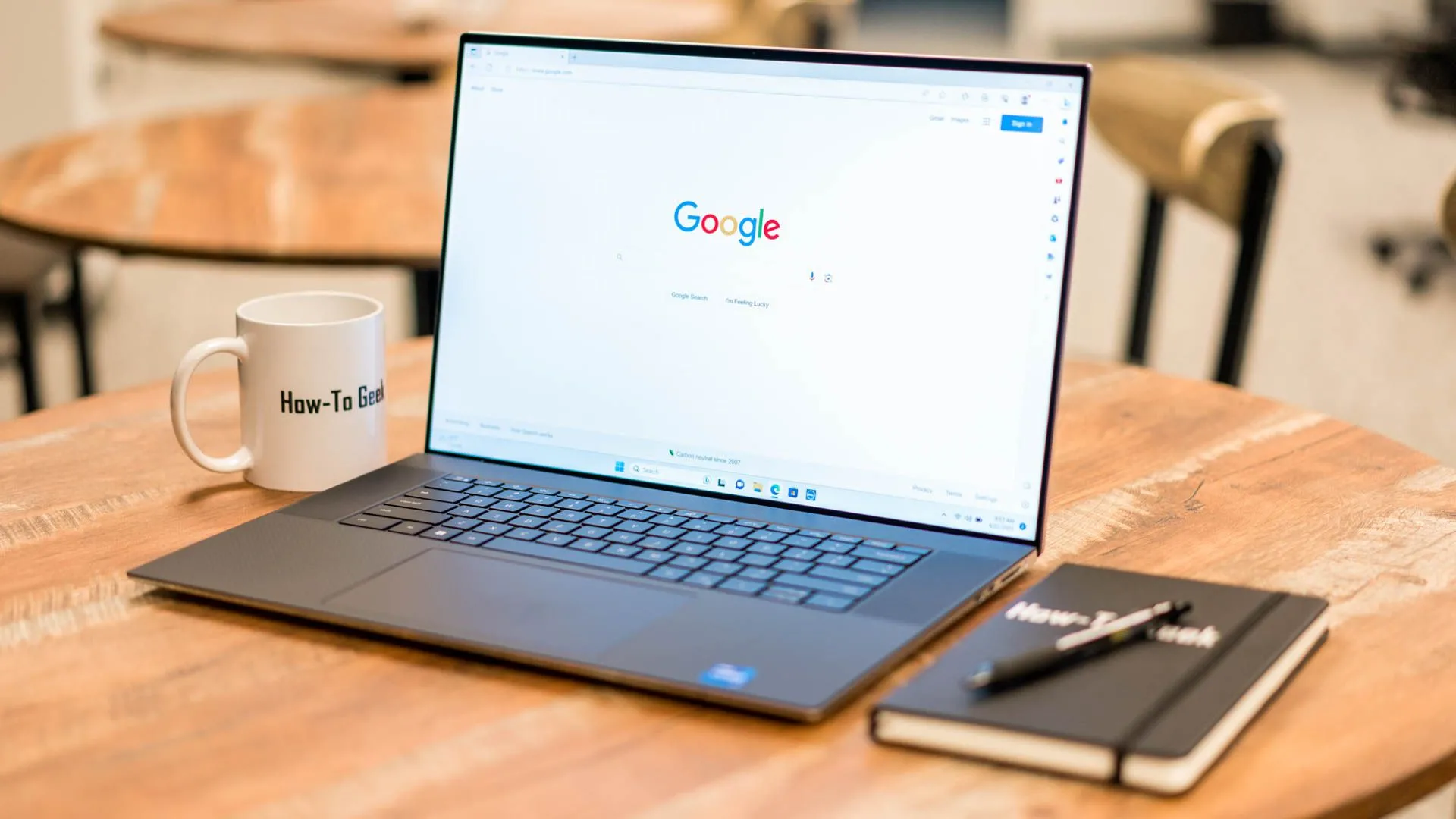 Một chiếc laptop Dell XPS 17 trên bàn cùng sổ tay, thể hiện việc lập kế hoạch công việc thủ công hoặc kỹ thuật số.
