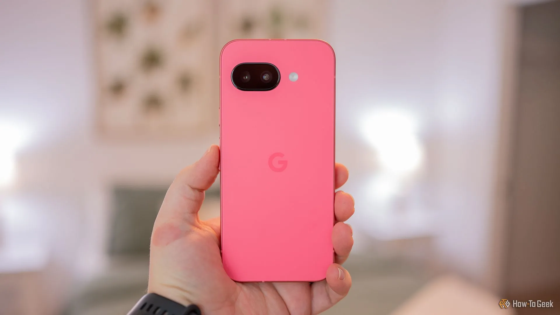 Một người đang cầm điện thoại Google Pixel 9a màu xanh lá, mặt lưng điện thoại lộ rõ