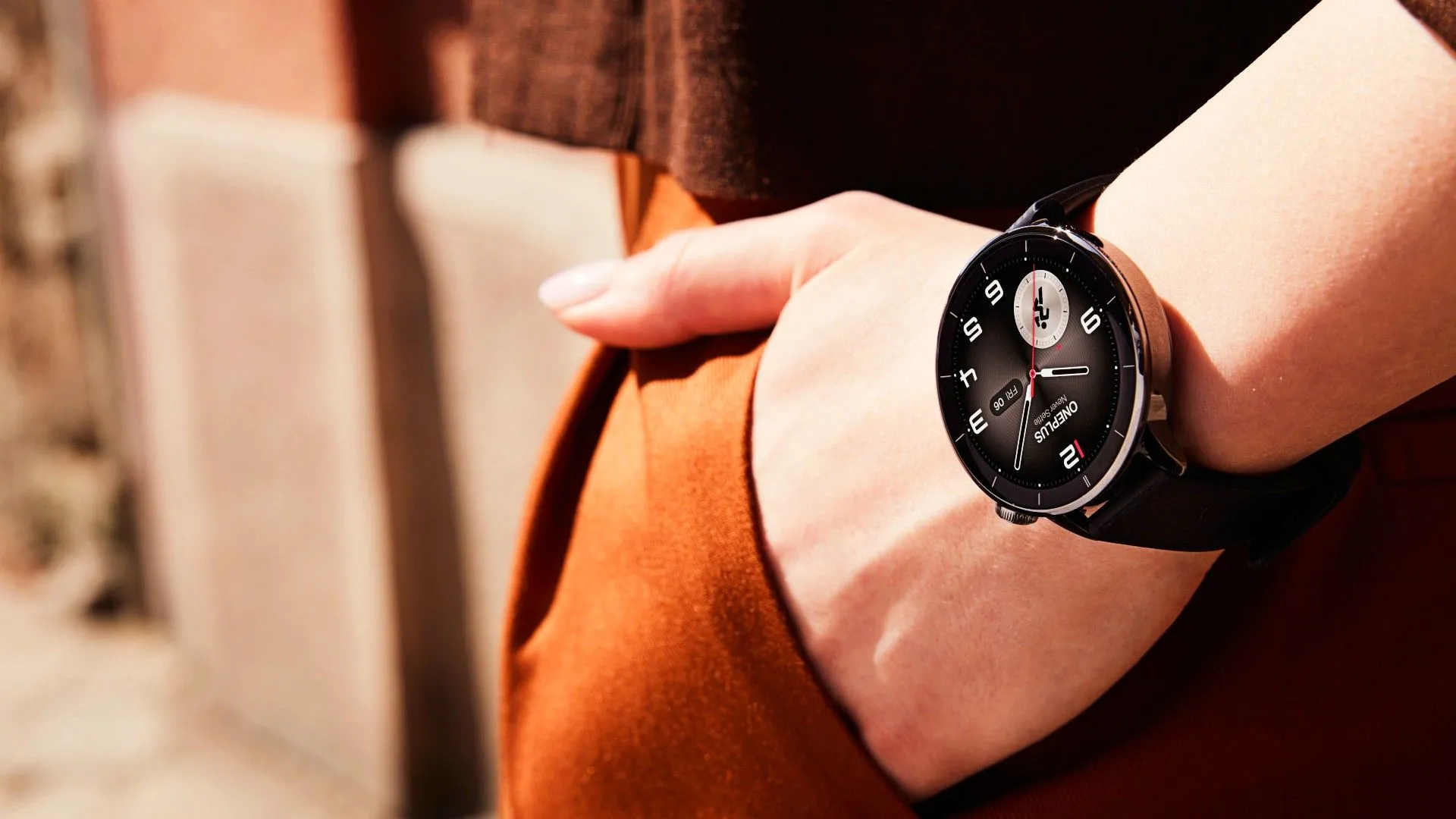 Một người đang đeo đồng hồ OnePlus Watch 3 màu đen trên cổ tay, tay họ để trong túi quần, tạo dáng tự nhiên