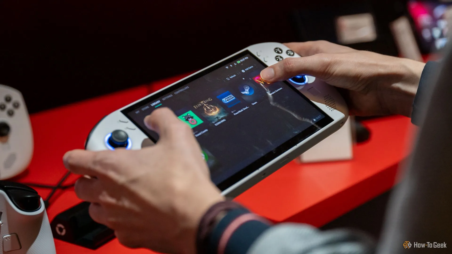 Một người đang thao tác trên màn hình chính của Lenovo Legion Go, minh họa kích thước lớn và trải nghiệm sử dụng của máy chơi game cầm tay hiện đại.