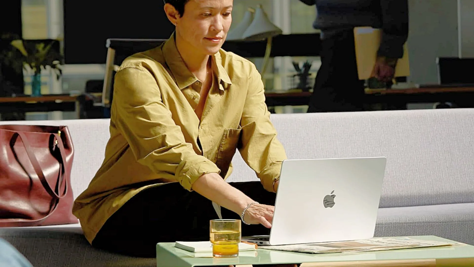Một người phụ nữ đang gõ bàn phím trên MacBook Pro 14 inch M4 đặt trên bàn