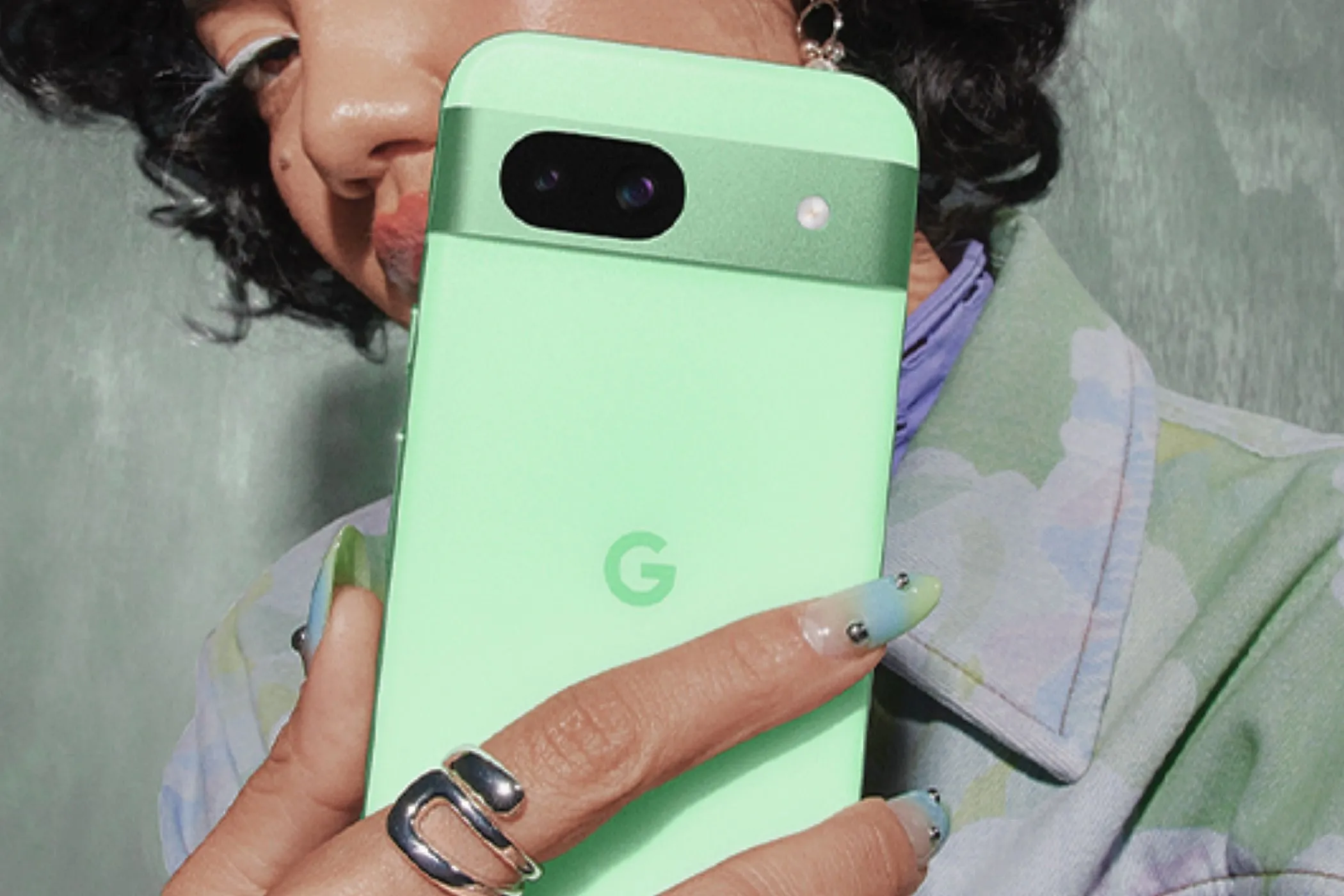 Một phụ nữ đang cầm chiếc Google Pixel 8a màu Aloe