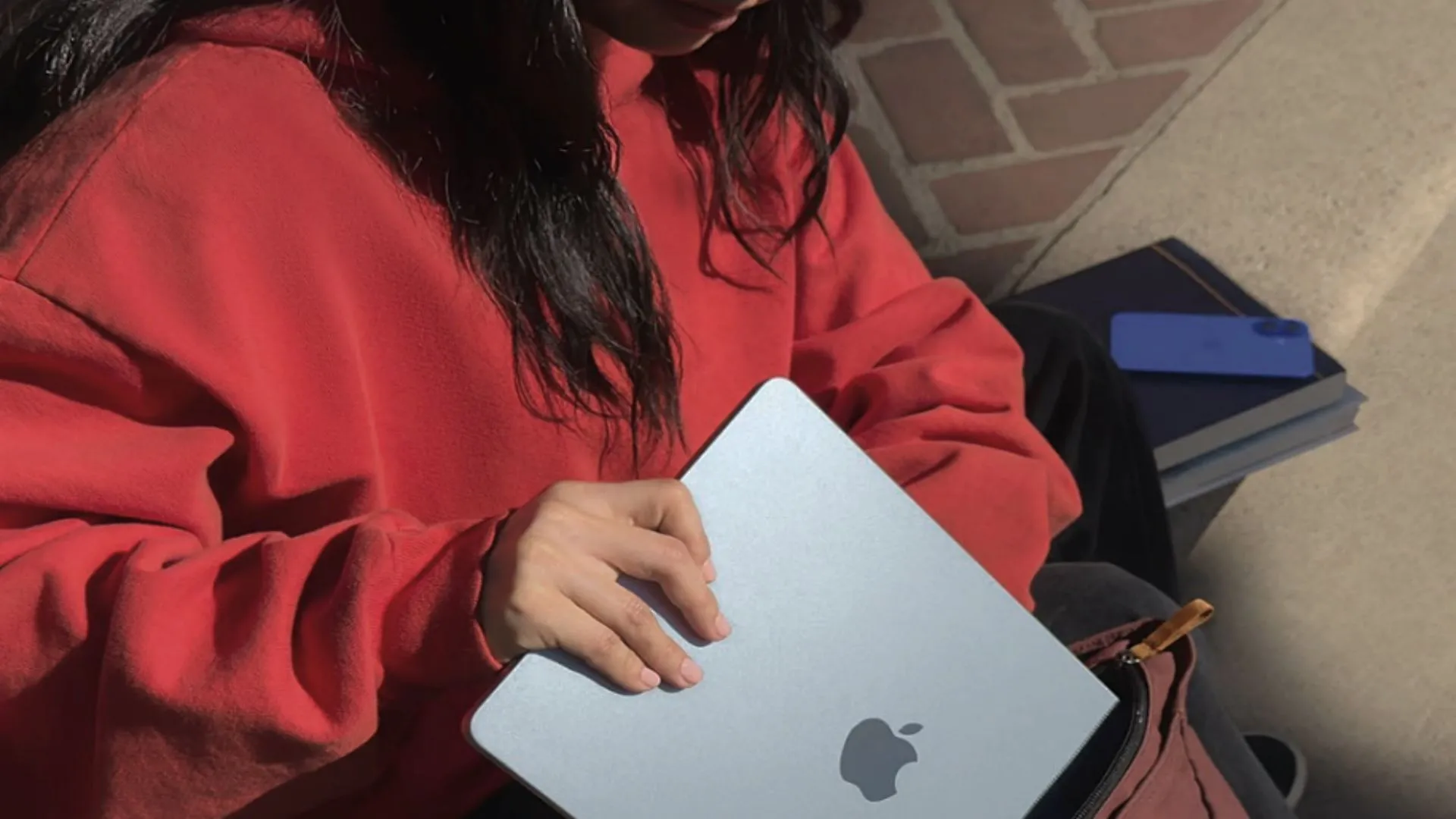 Một sinh viên đang bỏ MacBook Air 13 inch M4 vào cặp sách