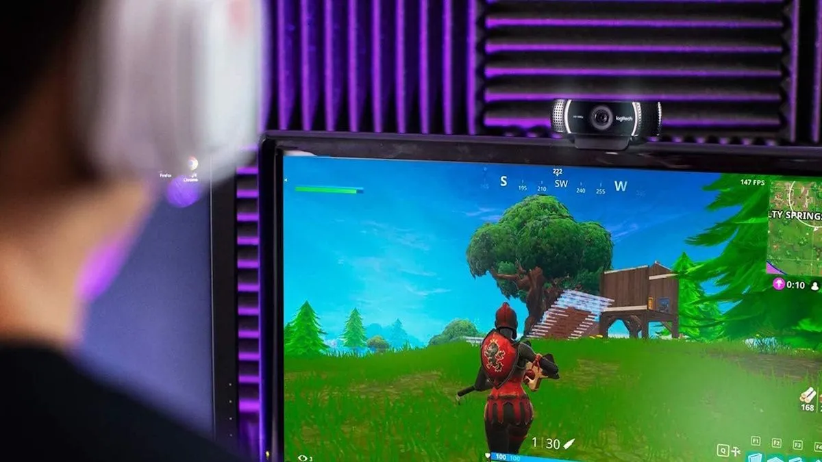 Một streamer đang chơi Fortnite, với webcam Logitech C922x được gắn phía trên màn hình
