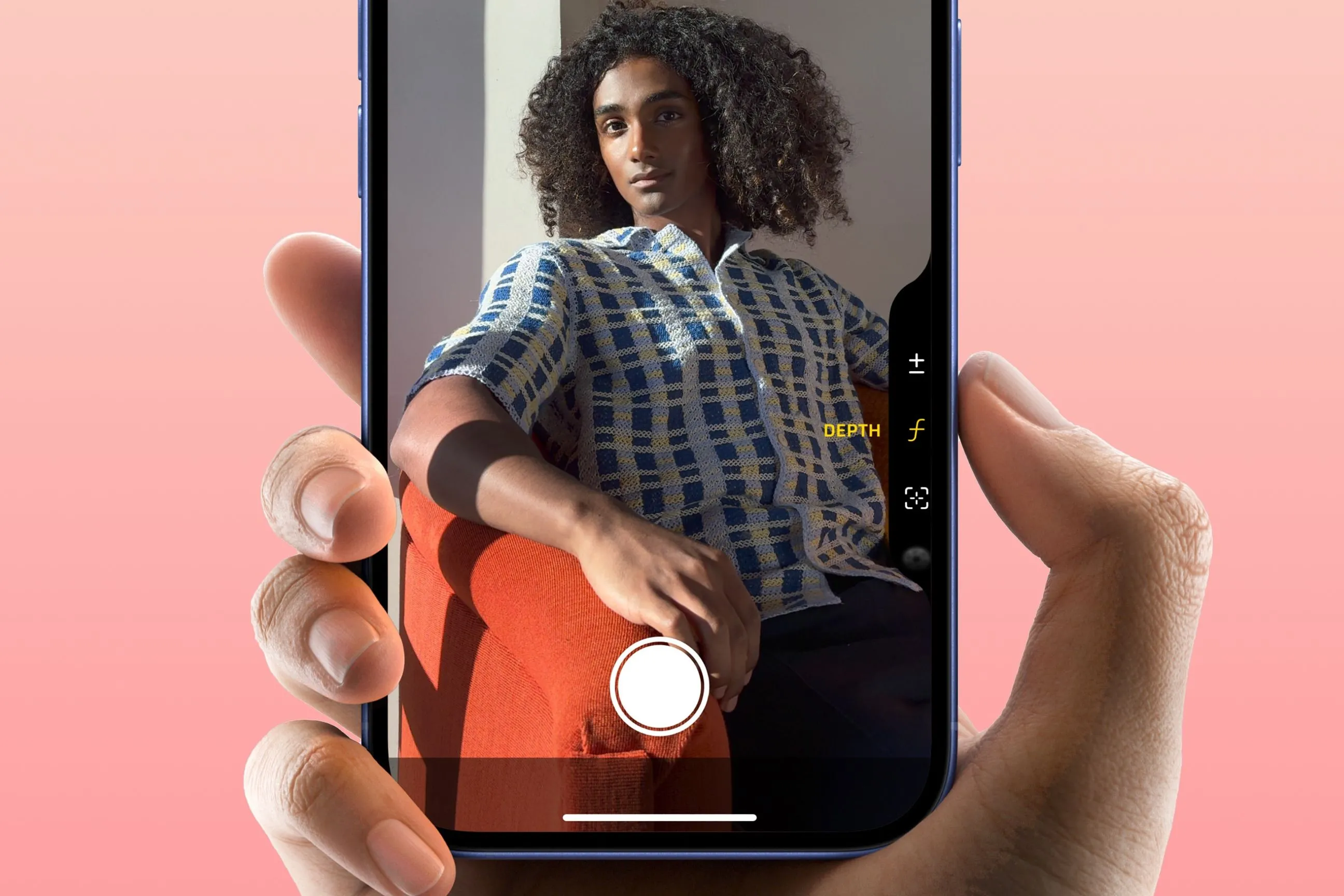 Ngón tay ấn vào nút Camera Control trên iPhone 16, minh họa sự tiện lợi và phản xạ theo thói quen.