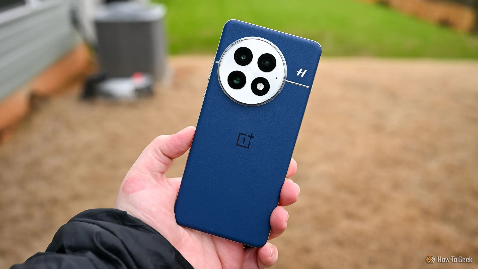 Người cầm OnePlus 13 màu xanh dương thể hiện mặt lưng và cụm camera