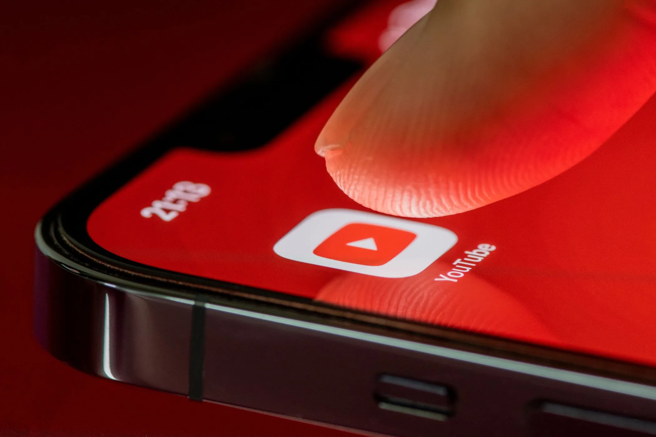 Người dùng chạm vào biểu tượng ứng dụng YouTube trên iPhone