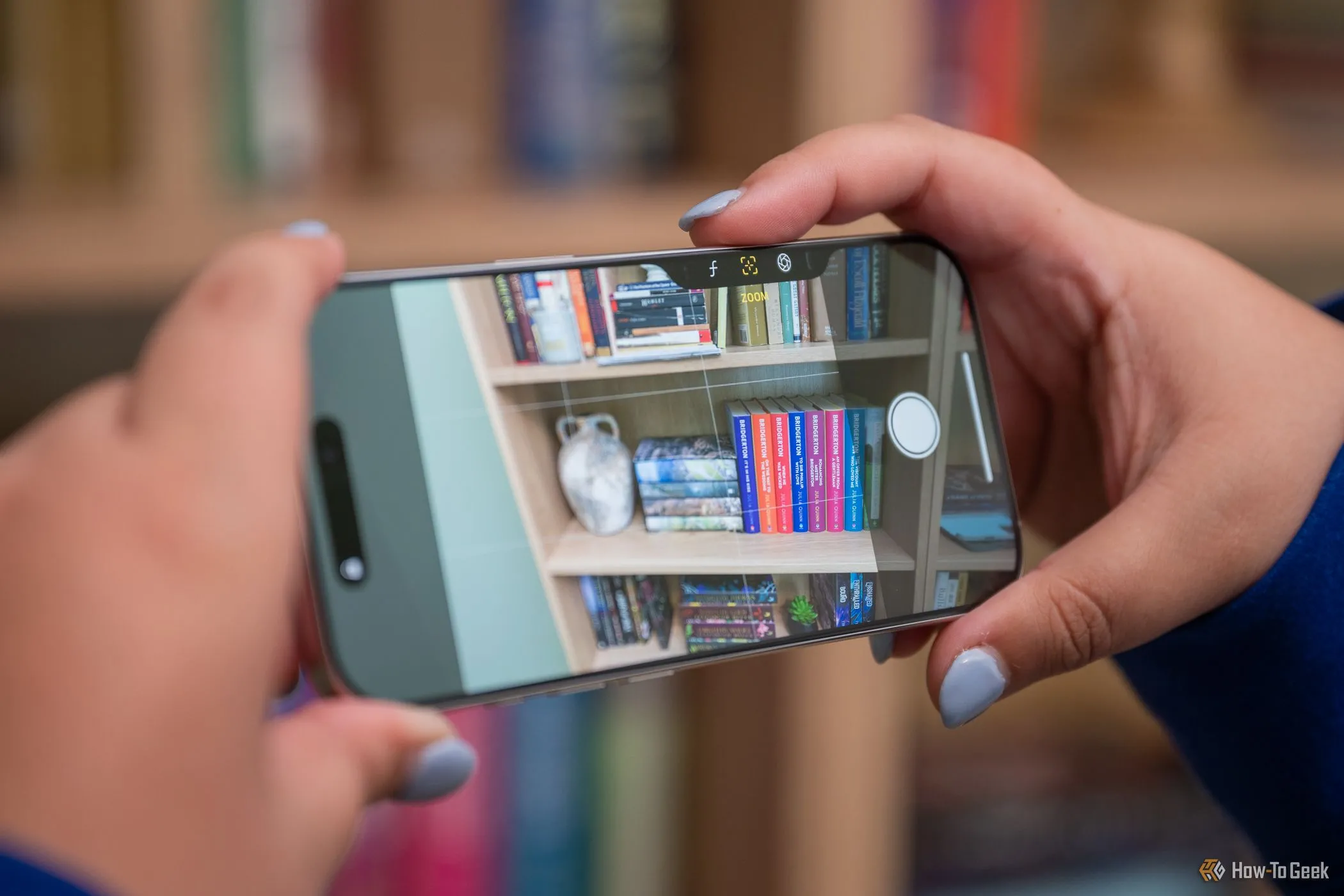 Người dùng điều chỉnh cài đặt camera bằng nút Camera Control trên iPhone 16 Pro khi chụp ngang, tối ưu các thông số.