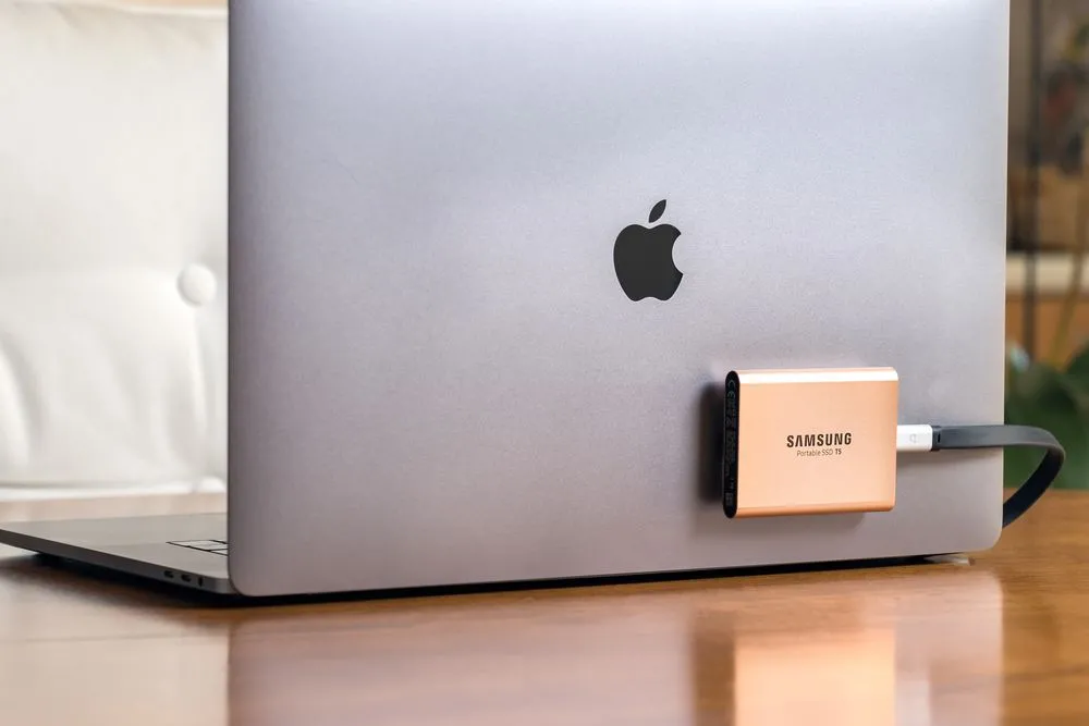 Ổ cứng SSD di động Samsung T5 kết nối với MacBook Pro bằng cáp ngắn, minh họa tính tiện lợi và nhỏ gọn.