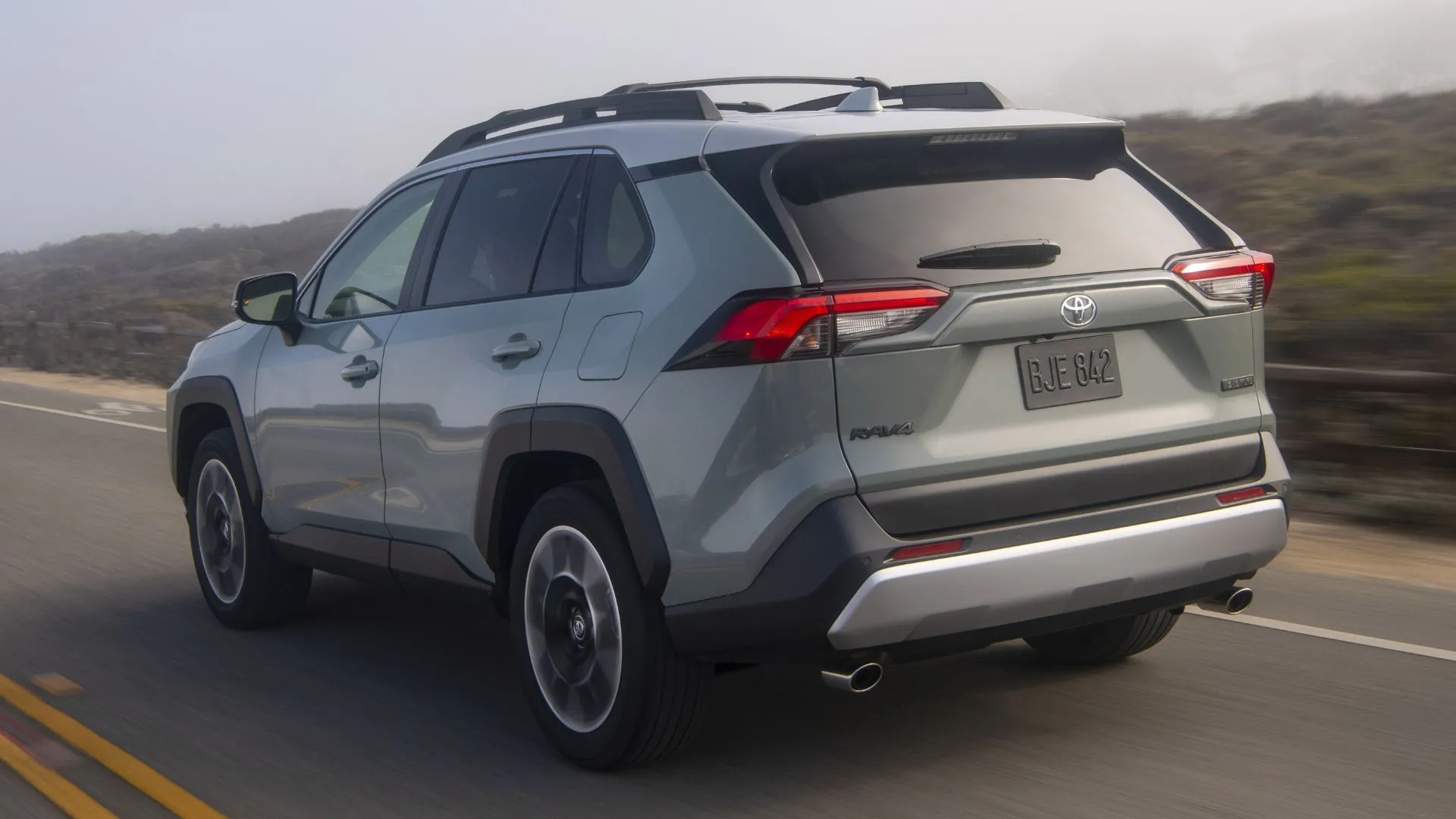 Phần đuôi của Toyota RAV4 2020 màu xám lịch lãm trên con đường nông thôn, minh họa cho tính thực dụng và bền bỉ của mẫu SUV này.