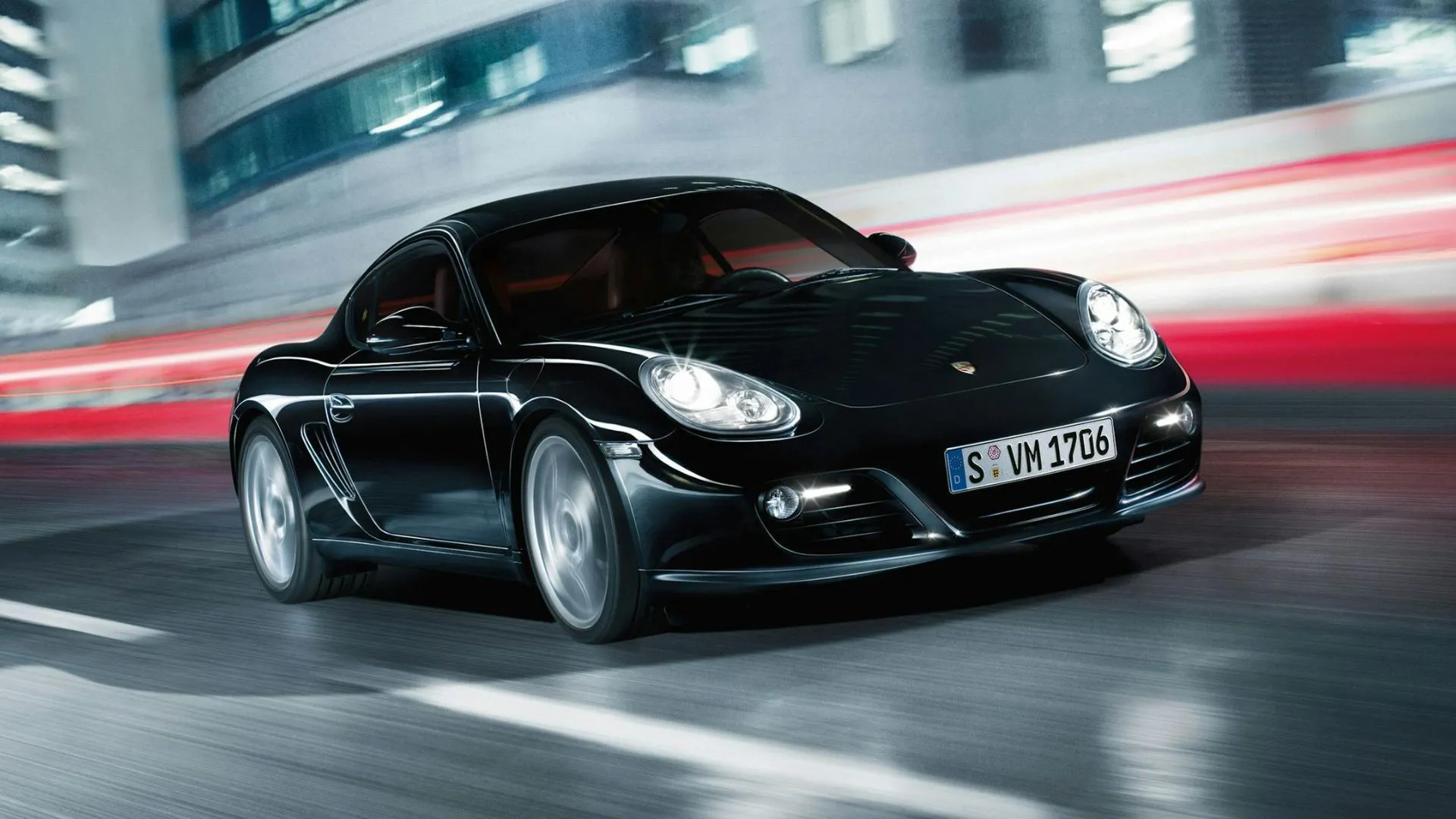 Porsche Cayman 981 màu đen đang vào cua trên đường đua, phô diễn khả năng xử lý đỉnh cao của dòng xe thể thao Porsche.