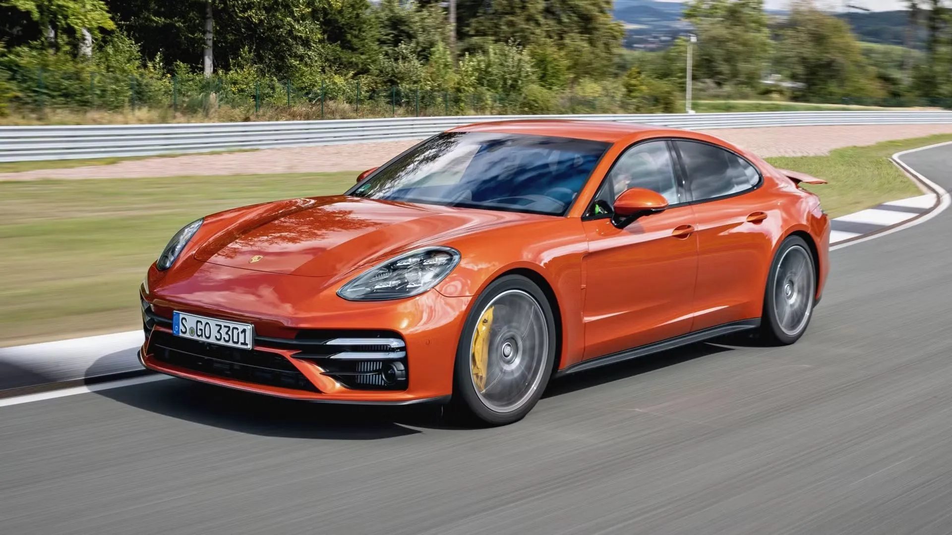 Porsche Panamera Turbo S 2021 màu cam rực rỡ lướt trên đường đua, biểu tượng của hiệu suất đỉnh cao
