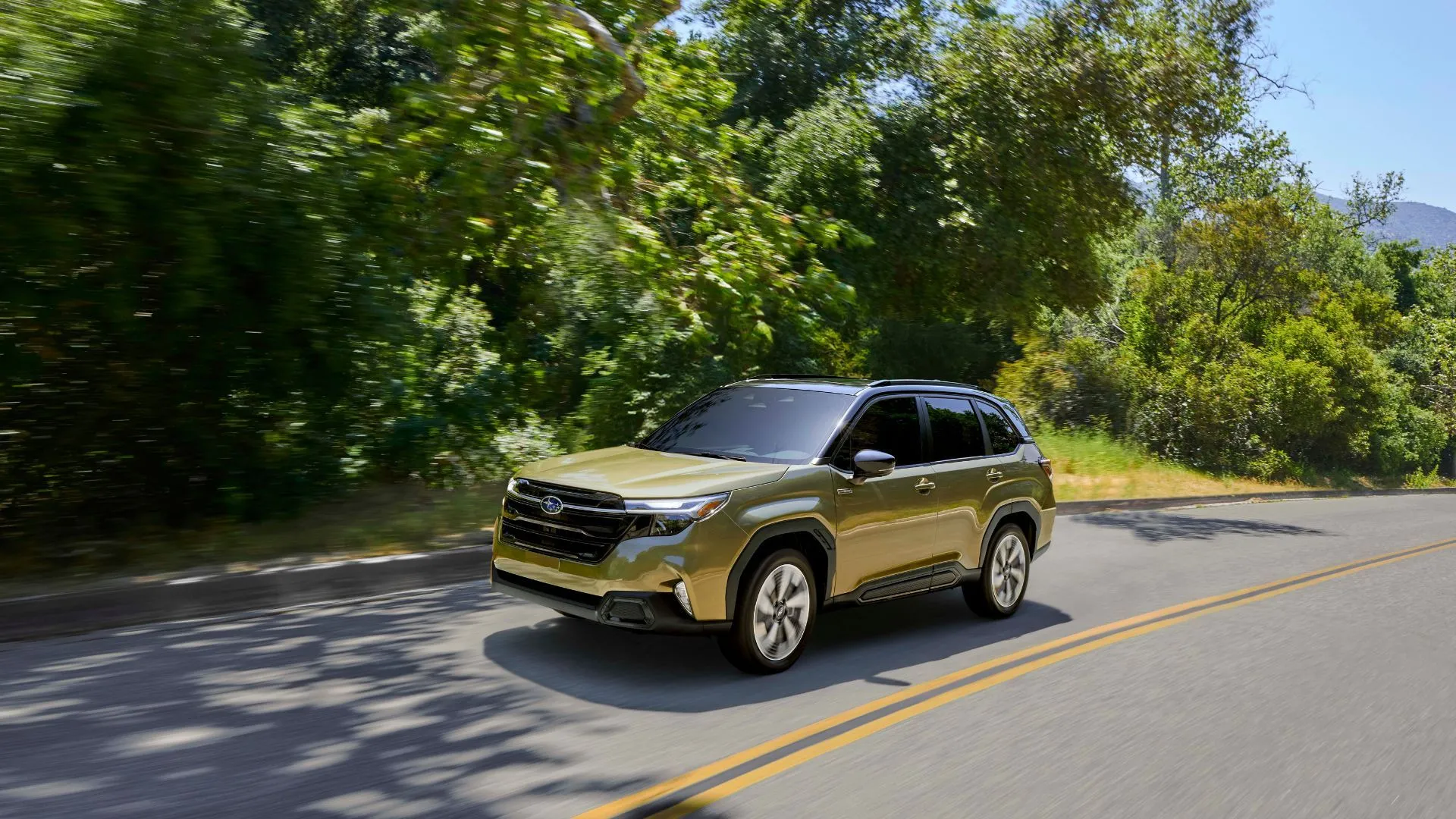 Subaru Forester Hybrid 2025 màu xanh lá đang chạy trên đường nông thôn, chụp góc 3/4 phía trước động