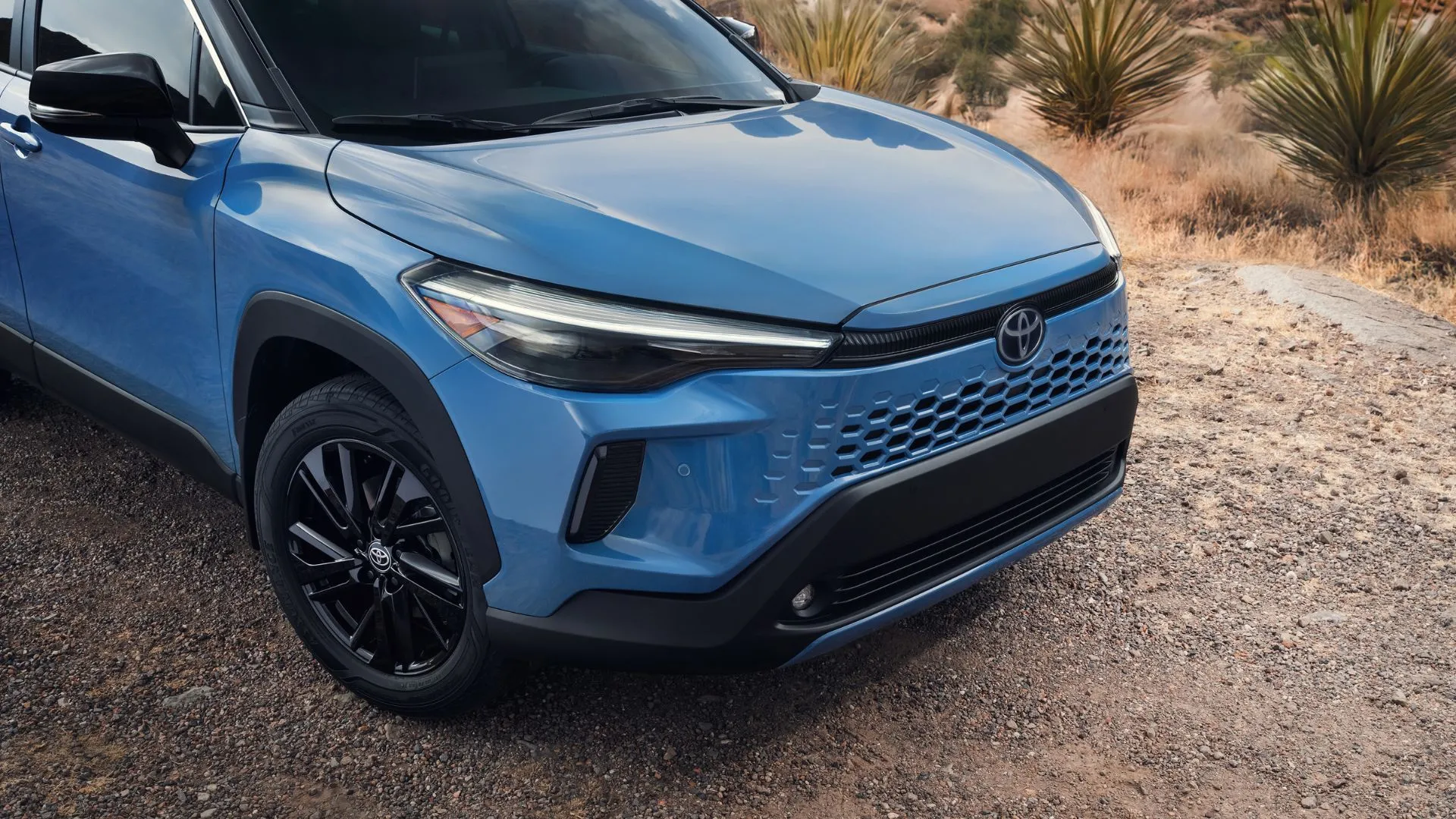 SUV Toyota Corolla Cross 2026 màu trắng, đứng vững trên con đường nông thôn, với những cải tiến về thiết kế và tính năng.