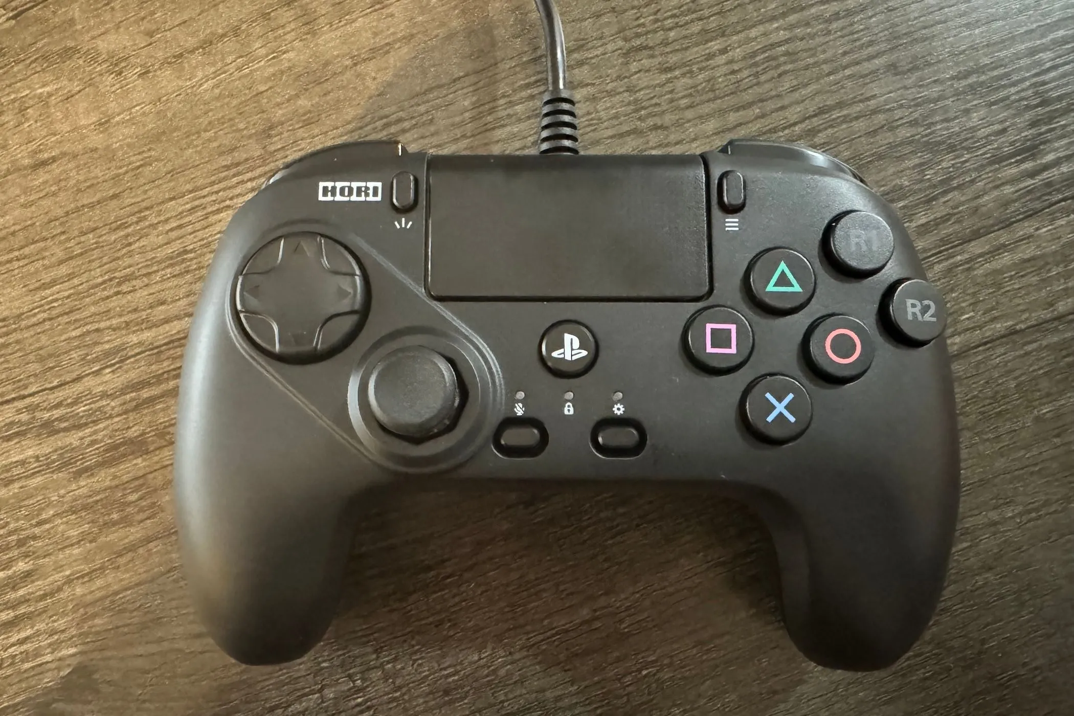 Tay cầm HORI Fightpad màu đen dành cho PlayStation với bố cục nút đặc biệt, đặt trên nền tối.