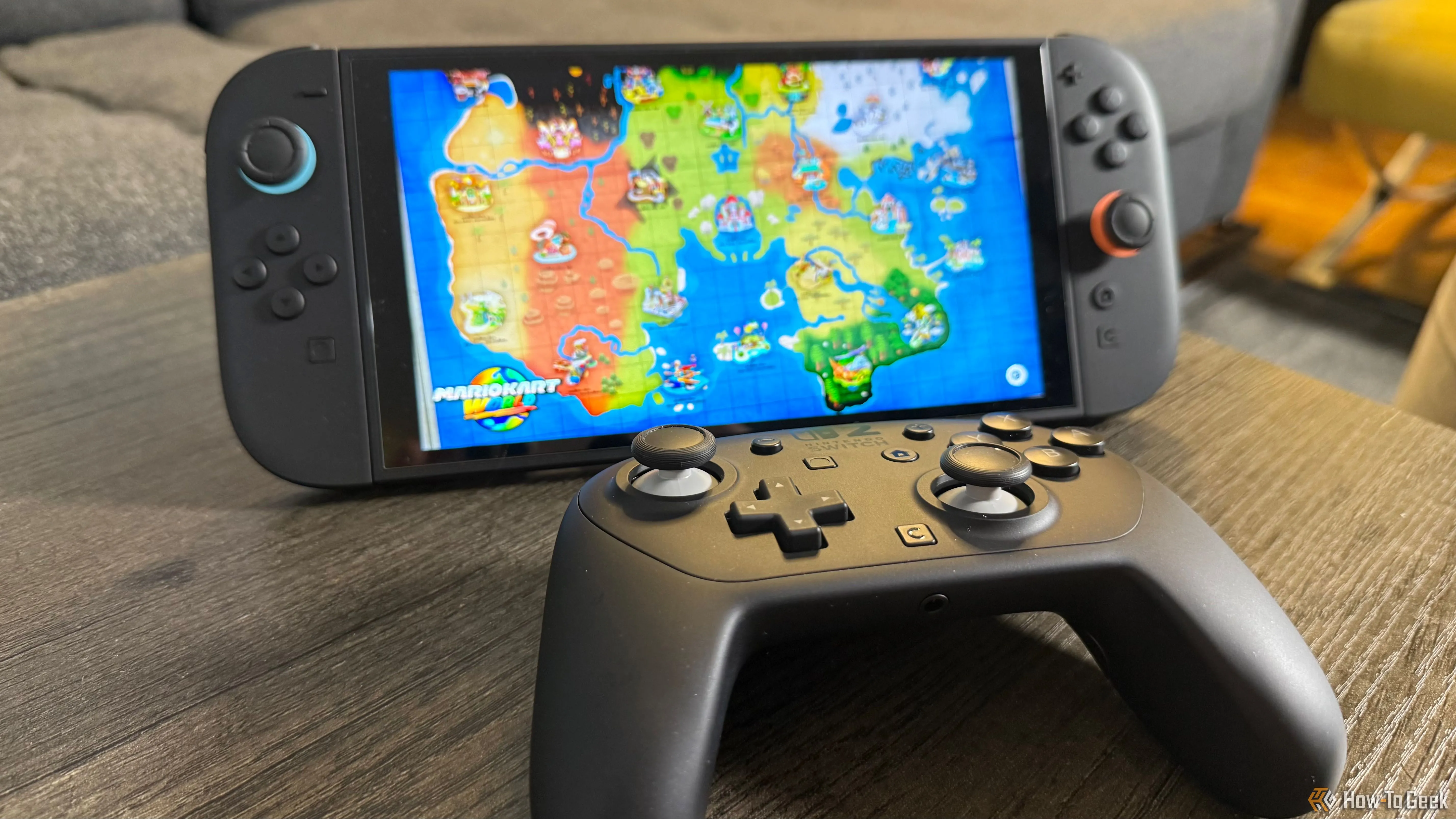 Tay cầm Nintendo Switch 2 Pro Controller đặt cạnh bảng điều khiển Switch 2 đang hiển thị trò chơi Mario Kart World