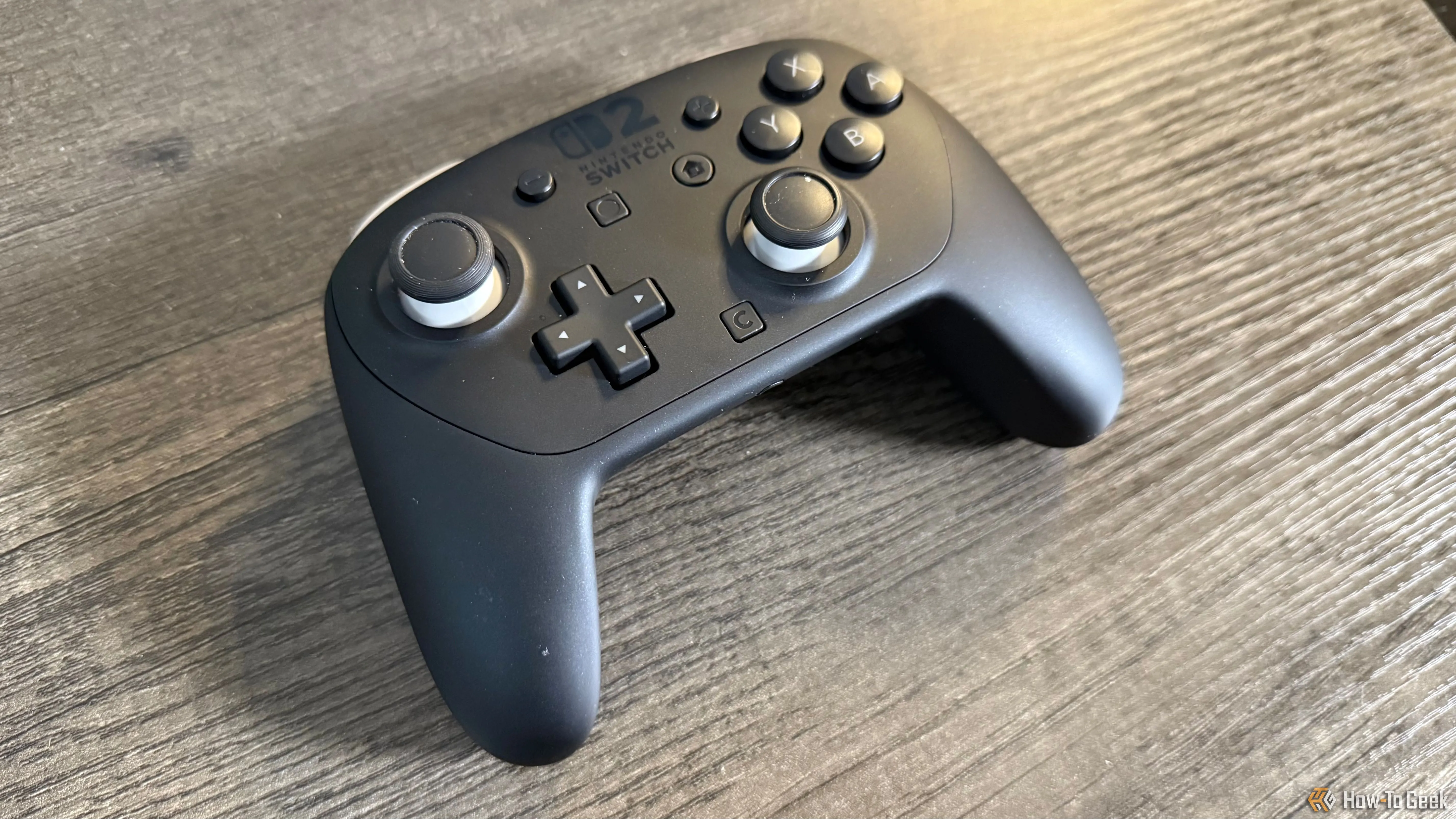 Tay cầm Nintendo Switch 2 Pro Controller đặt trên bàn nhìn từ trên xuống, làm nổi bật thiết kế công thái học