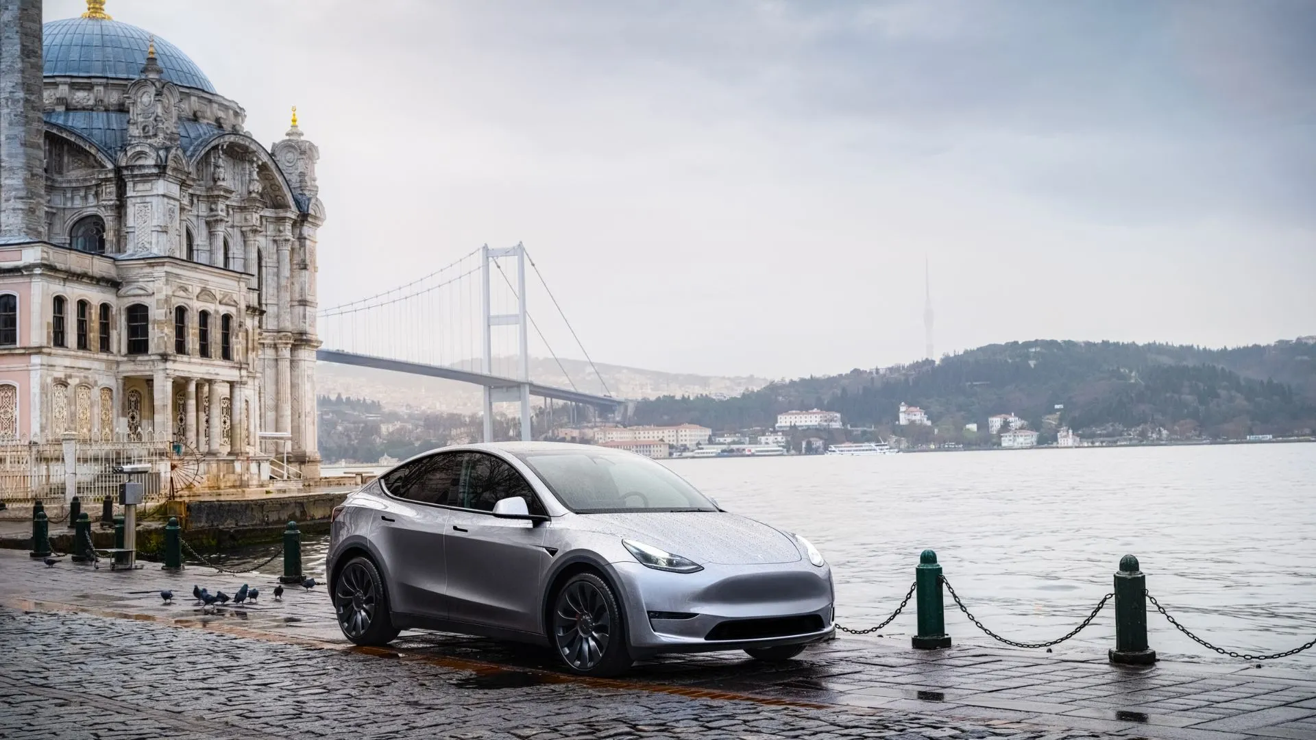 Tesla Model Y màu bạc sang trọng đỗ cạnh bờ biển, thể hiện thiết kế xe điện crossover.