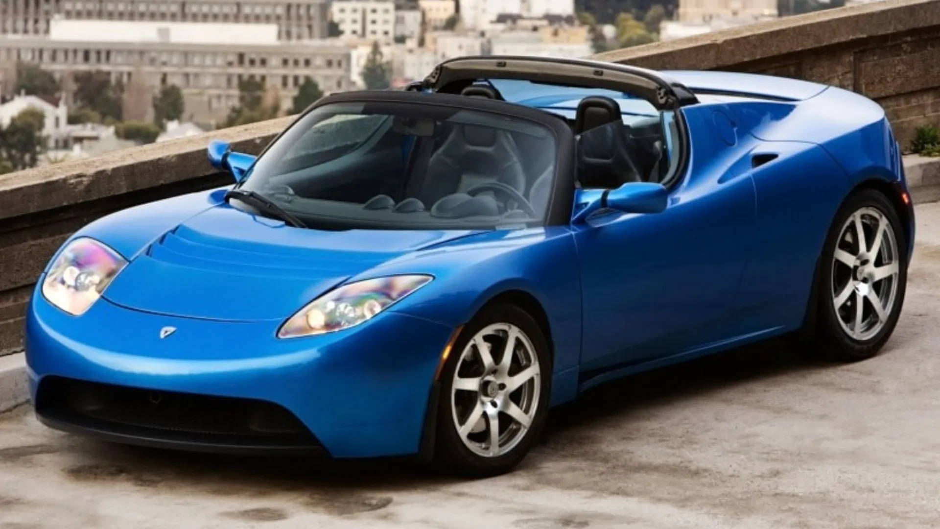 Tesla Roadster thế hệ đầu tiên màu xanh đậu trên sân thượng, xe thể thao điện tầm xa đột phá.