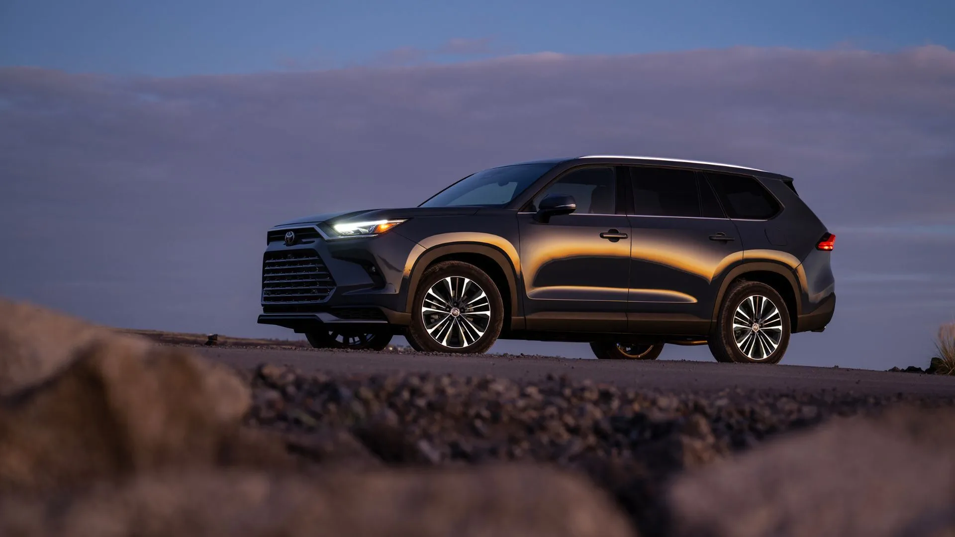 Thân xe Toyota Grand Highlander Hybrid 2025 màu đen, cho thấy kích thước lớn và thiết kế năng động, là lựa chọn hàng đầu cho xe gia đình 3 hàng ghế.