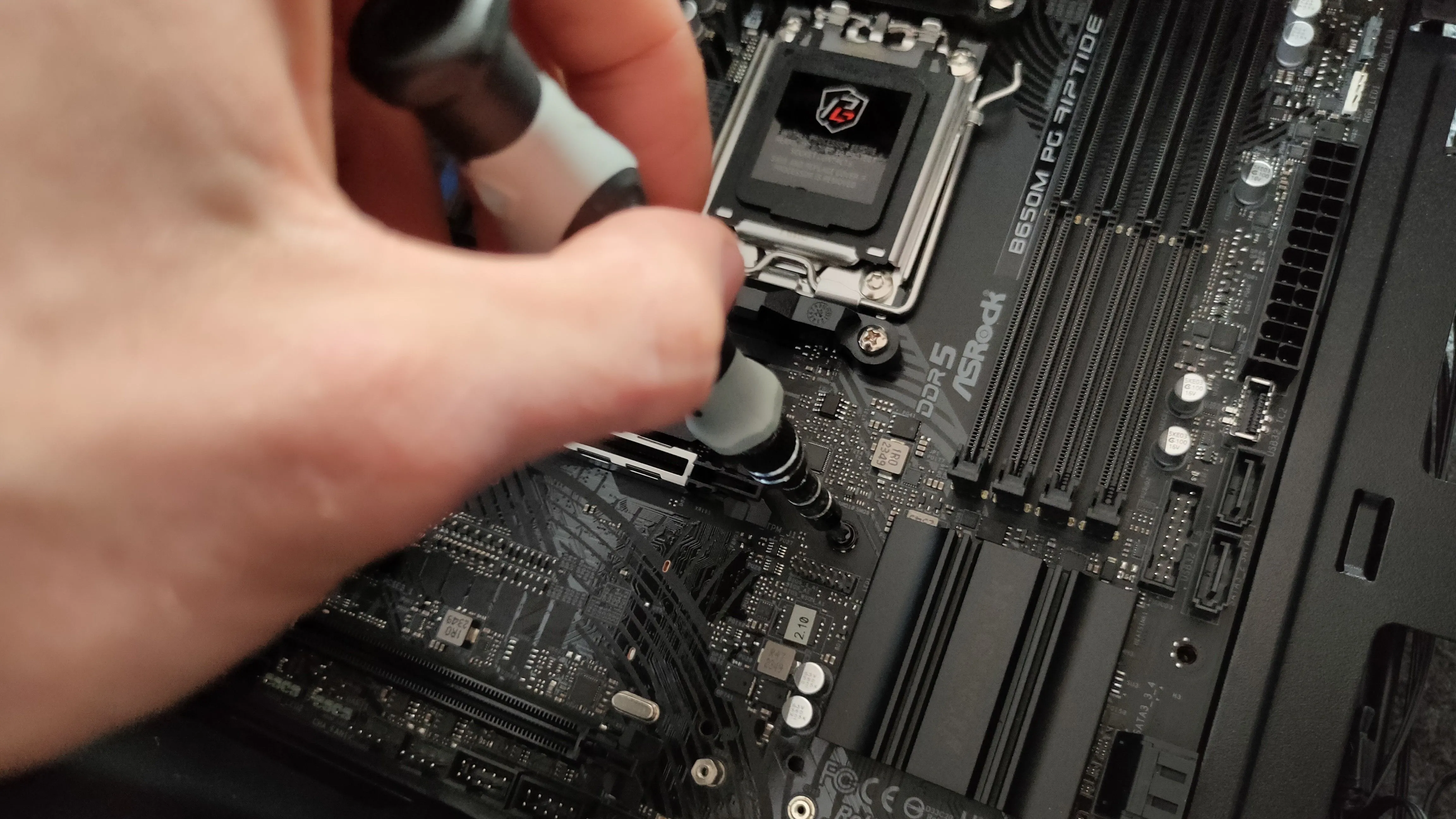 Thao tác vặn ốc cố định mainboard vào vỏ case máy tính, đảm bảo chắc chắn và đúng vị trí