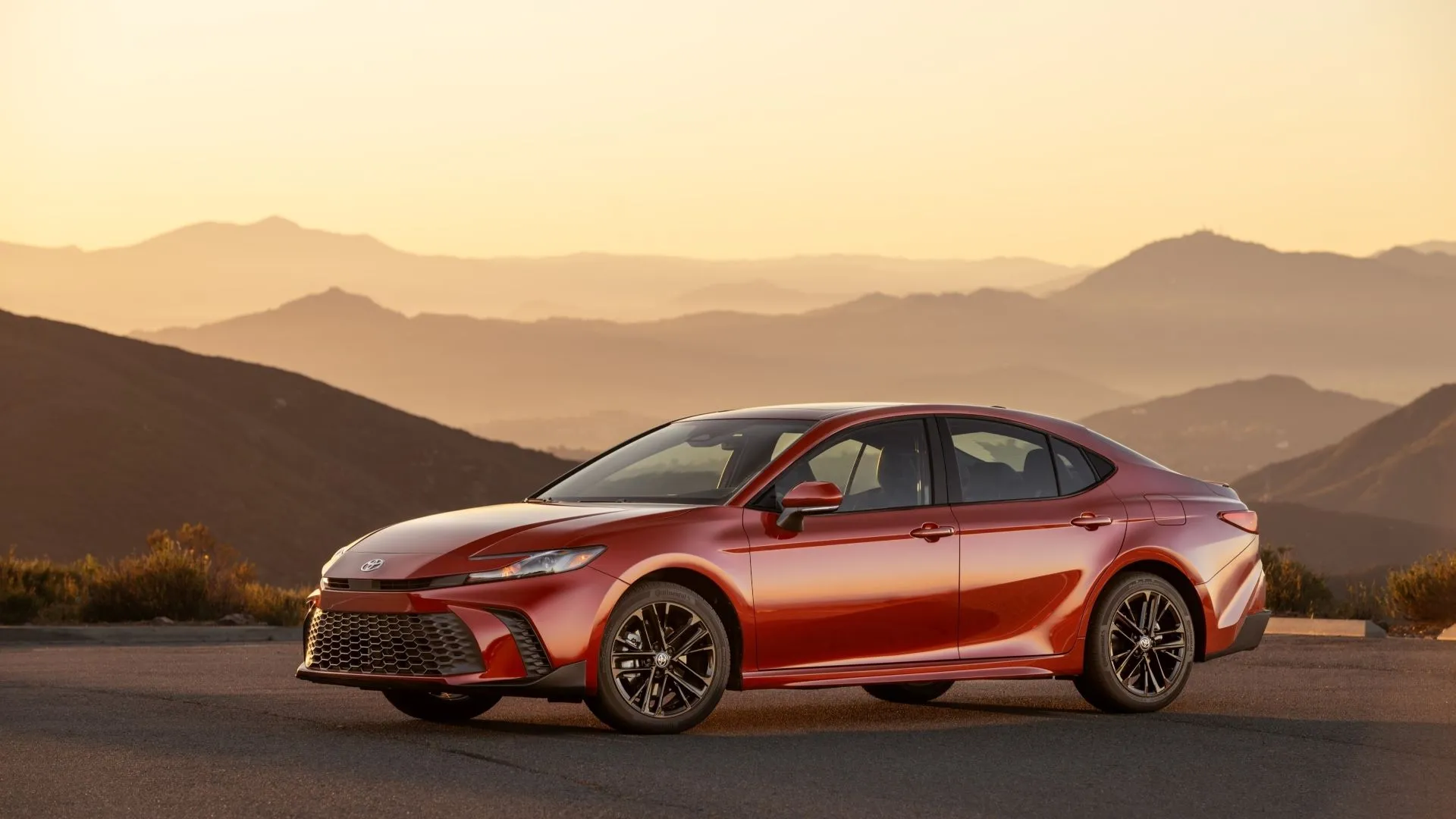 Toyota Camry 2025 màu đỏ Supersonic Red với góc nhìn 3/4 phía trước, làm nổi bật thiết kế năng động và hệ dẫn động AWD
