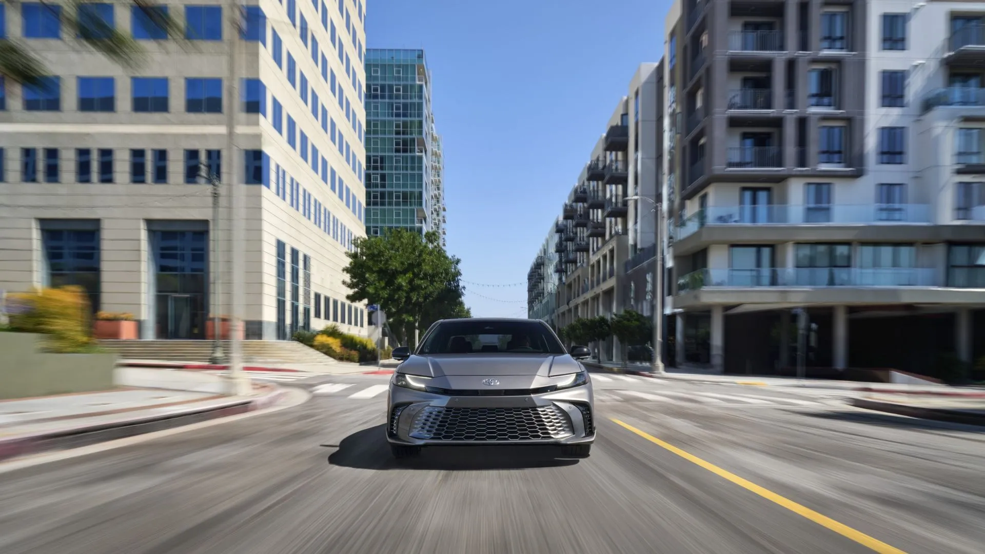 Toyota Camry XSE 2025 màu xám bạc di chuyển trên đường phố, thể hiện thiết kế sắc sảo và khả năng vận hành linh hoạt
