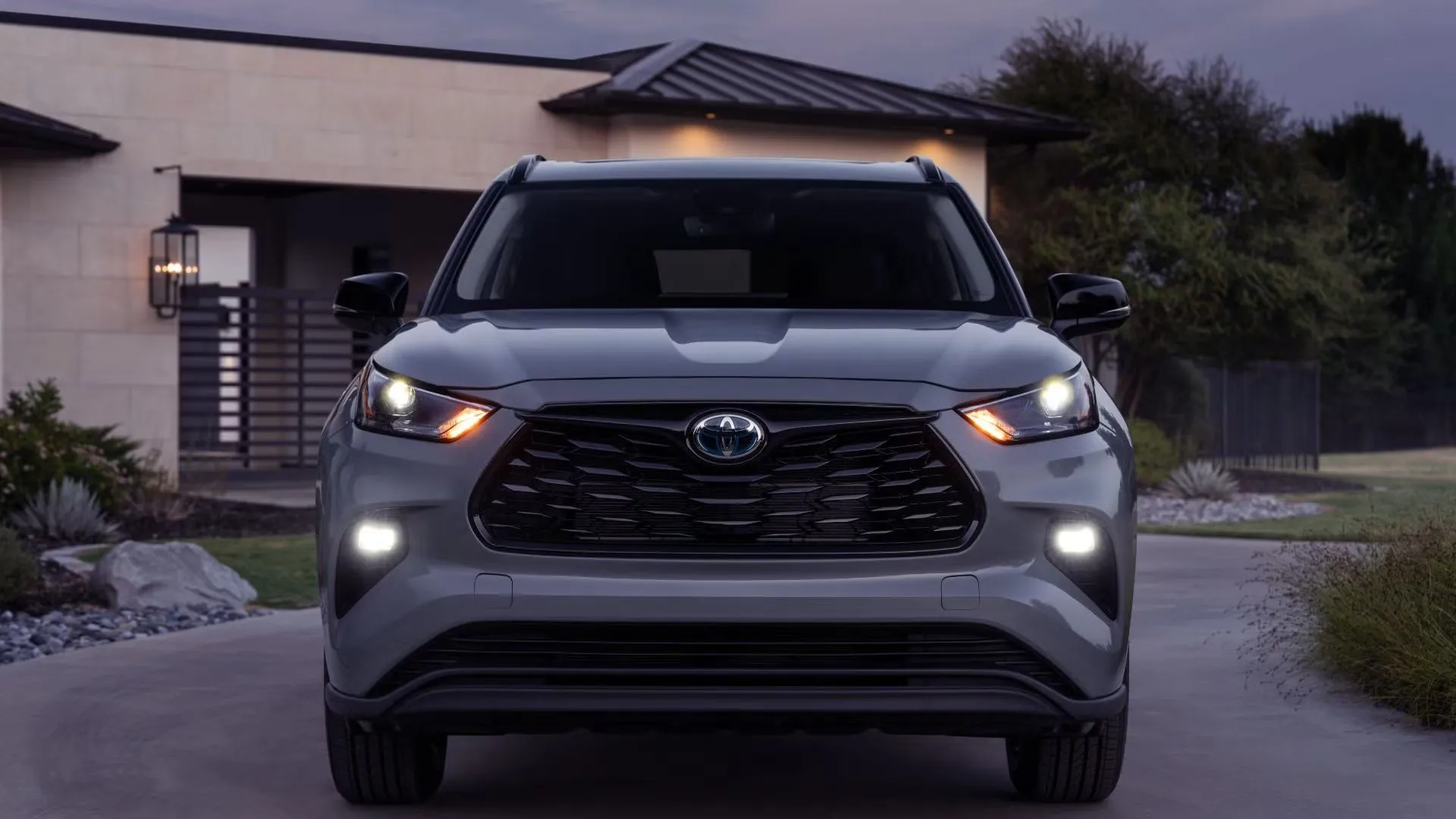 Toyota Highlander 2024 màu xám đậu trước nhà, thể hiện vẻ ngoài trang nhã và phù hợp cho gia đình với nội thất 3 hàng ghế.